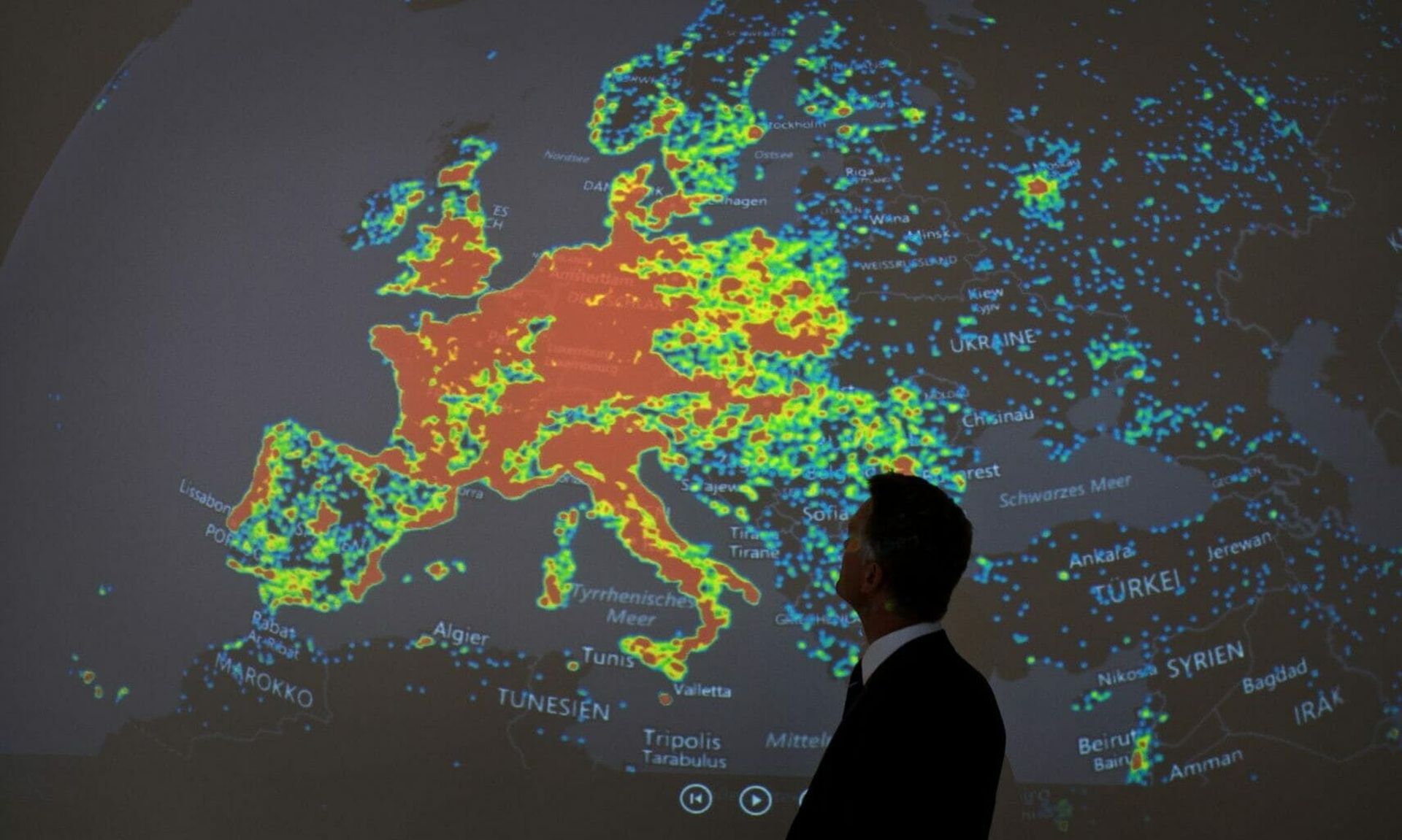 A man stands in front of a picture displaying activities of a so-called “botnet” during a workshop. (BORIS ROESSLER/DPA/AFP via Getty Images)