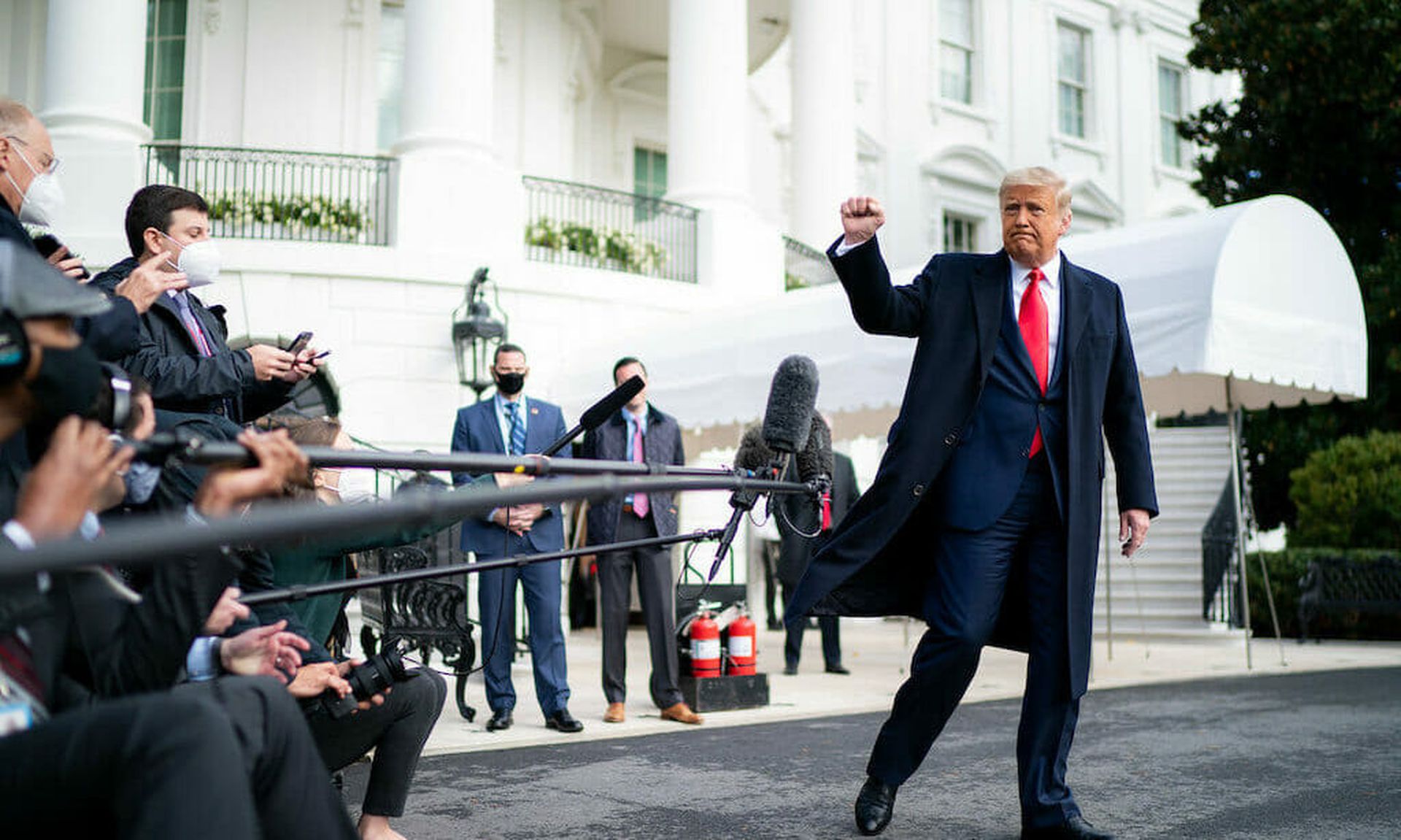 President Donald Trump gives a fist bump to the press Friday, Oct. 30, 2020, prior to boarding Marine One en route to Joint Base Andrews, Md. to begin his trip to Michigan, Wisconsin and Minnesota. (Official White House Photo by Tia Dufour)
