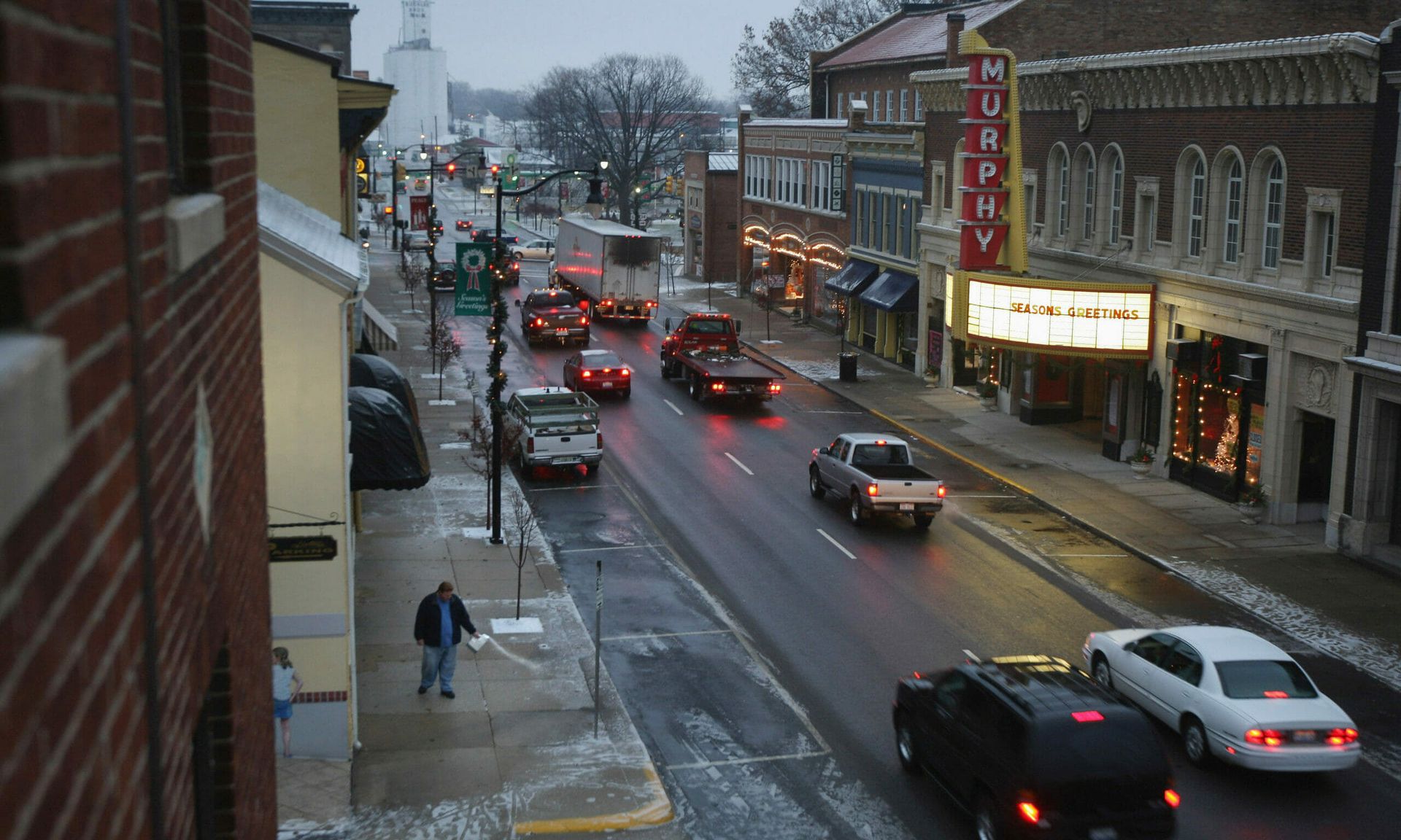 A merchant throws salt on an icy sidewalk along Main Street  in Wilmington, Ohio.  (Photo by John Moore/Getty Images)