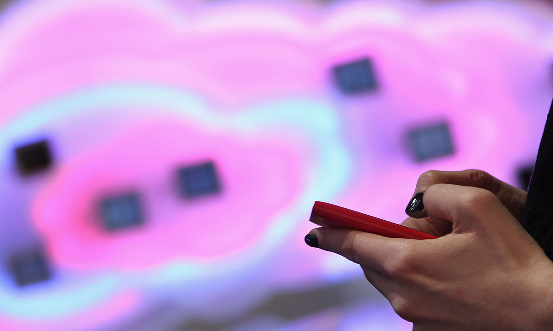 A visitor tries out a smartphone next to a symbol of a cloud at the CeBIT 2012 technology trade March 5, 2012, in Hanover, Germany. (Photo by Sean Gallup/Getty Images)