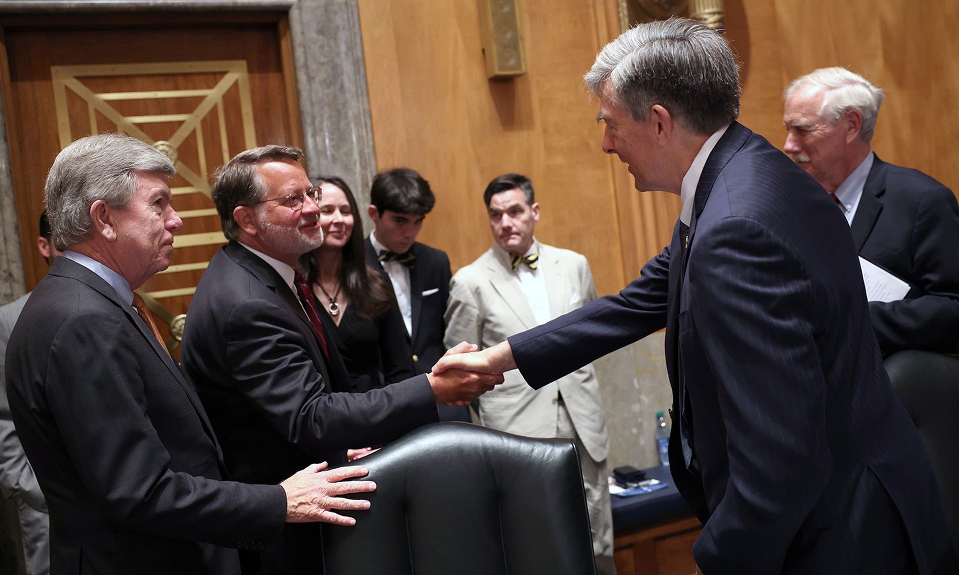 Senate Homeland Security Chairman Gary Peters, D-Mich., second from left, greets Chris Inglis, nominee to be the national cyber director, right, as Sen. Roy Blunt, R-Mo., left, and Jen Easterly, nominee to be the director of the Homeland Security Cybersecurity and Infrastructure Security Agency, watches during their confirmation hearing before the ...