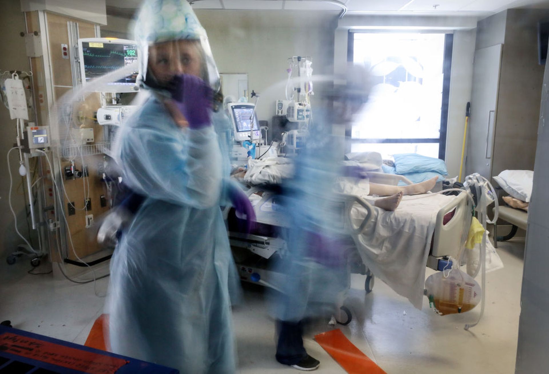 SAN DIEGO, CALIFORNIA &#8211; MAY 06: (EDITORIAL USE ONLY)  A nurse wearing personal protective equipment (PPE) speaks on a walkie talkie in the room of a COVID-19 patient in the Intensive Care Unit (ICU) at Sharp Memorial Hospital amidst the coronavirus pandemic on May 6, 2020 in San Diego, California. To reduce the number of times needed to enter...