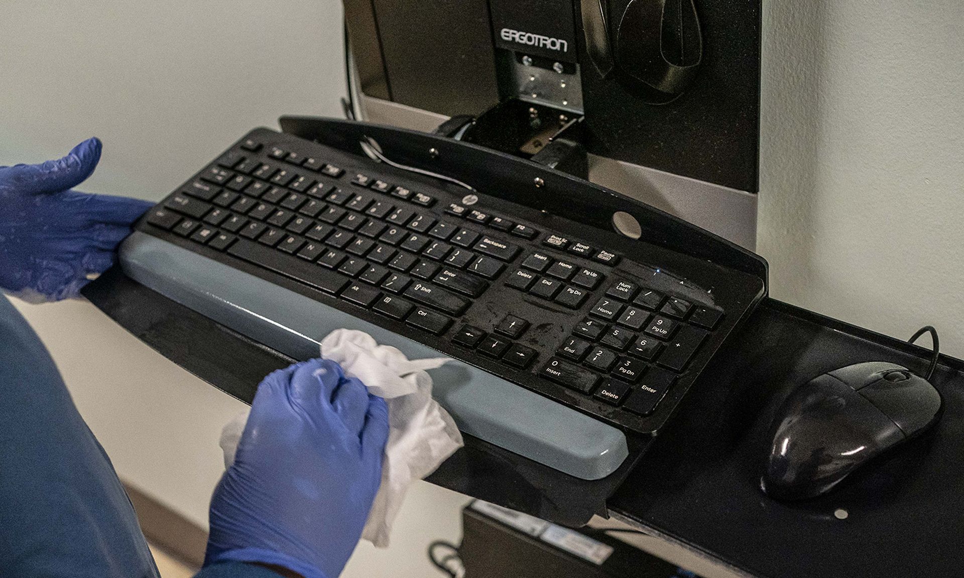 Aster Mekonen disinfects a computer workstation during her cleaning shift at Harborview Medical Center on Aug. 20, 2020, in Seattle. (Photo by David Ryder/Getty Images)