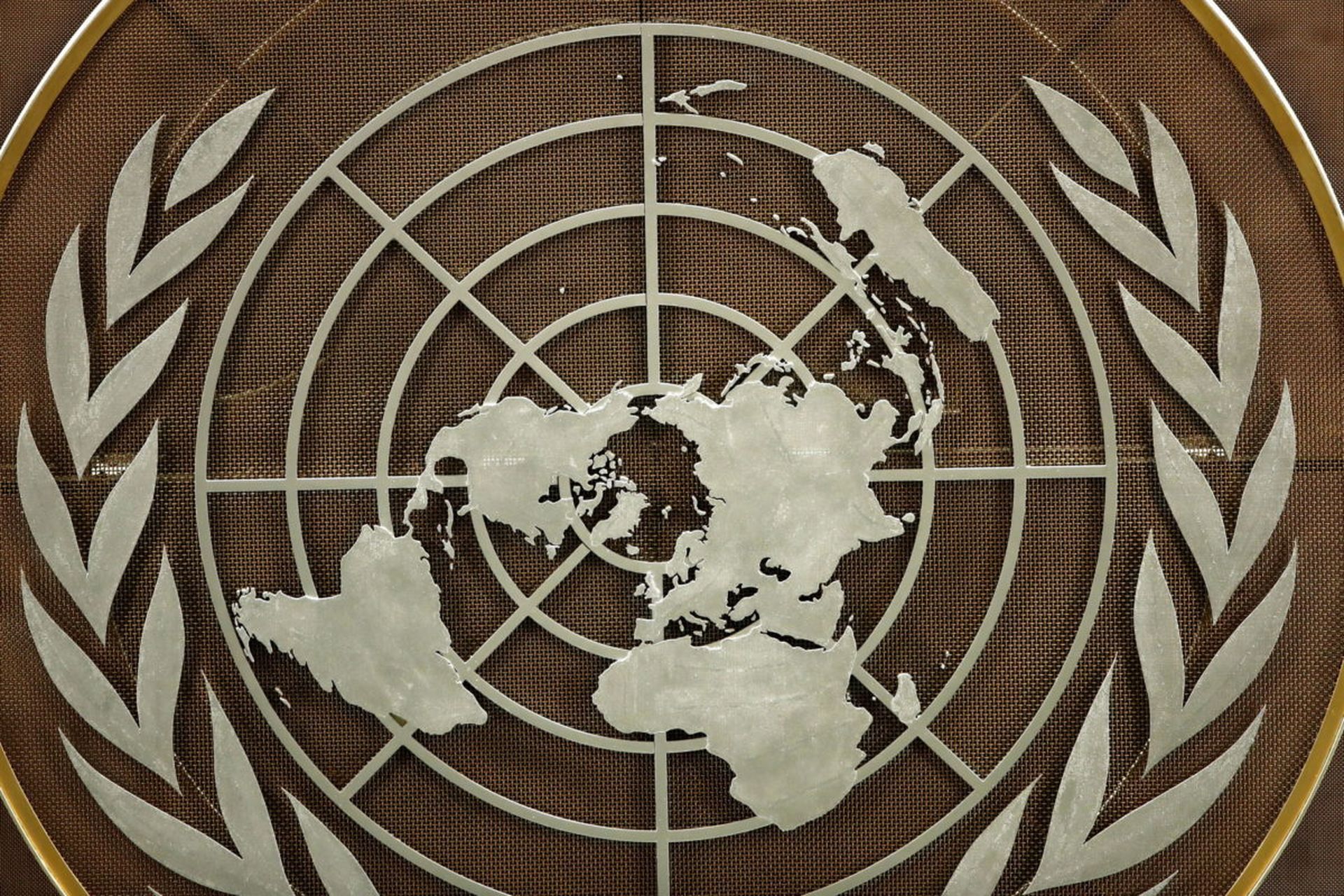 The logo of the United Nations is seen in the General Assembly hall before heads of state begin to address the 76th Session of the U.N. General Assembly at UN Headquarters on September 21, 2021 in New York City. International and cyber policy experts are grappling with how much involvement private industry should have when it comes to shaping cyber...