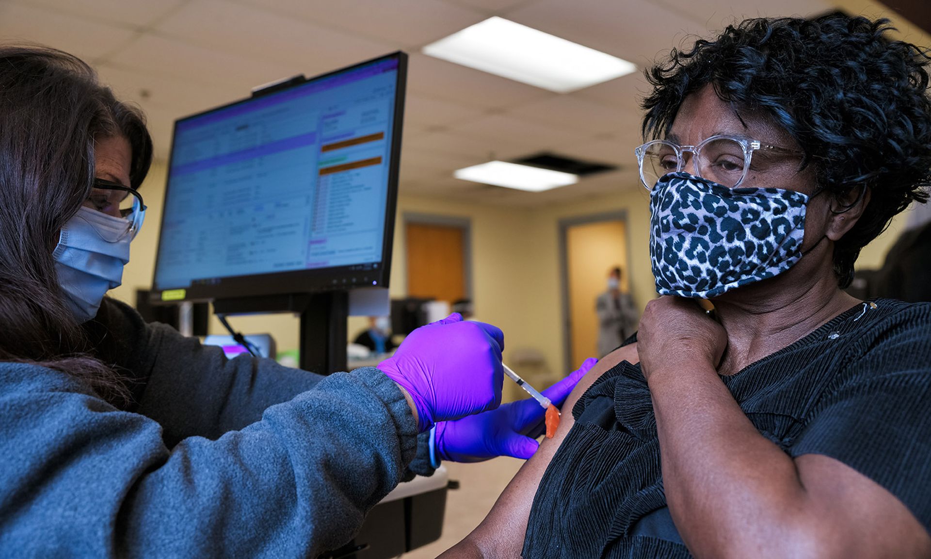 A woman is given a Moderna COVID-19 vaccine by a medical technician in Bates Memorial Baptist Church in Louisville, Ky., on Feb. 12, 2021. (Photo by Jon Cherry/Getty Images)