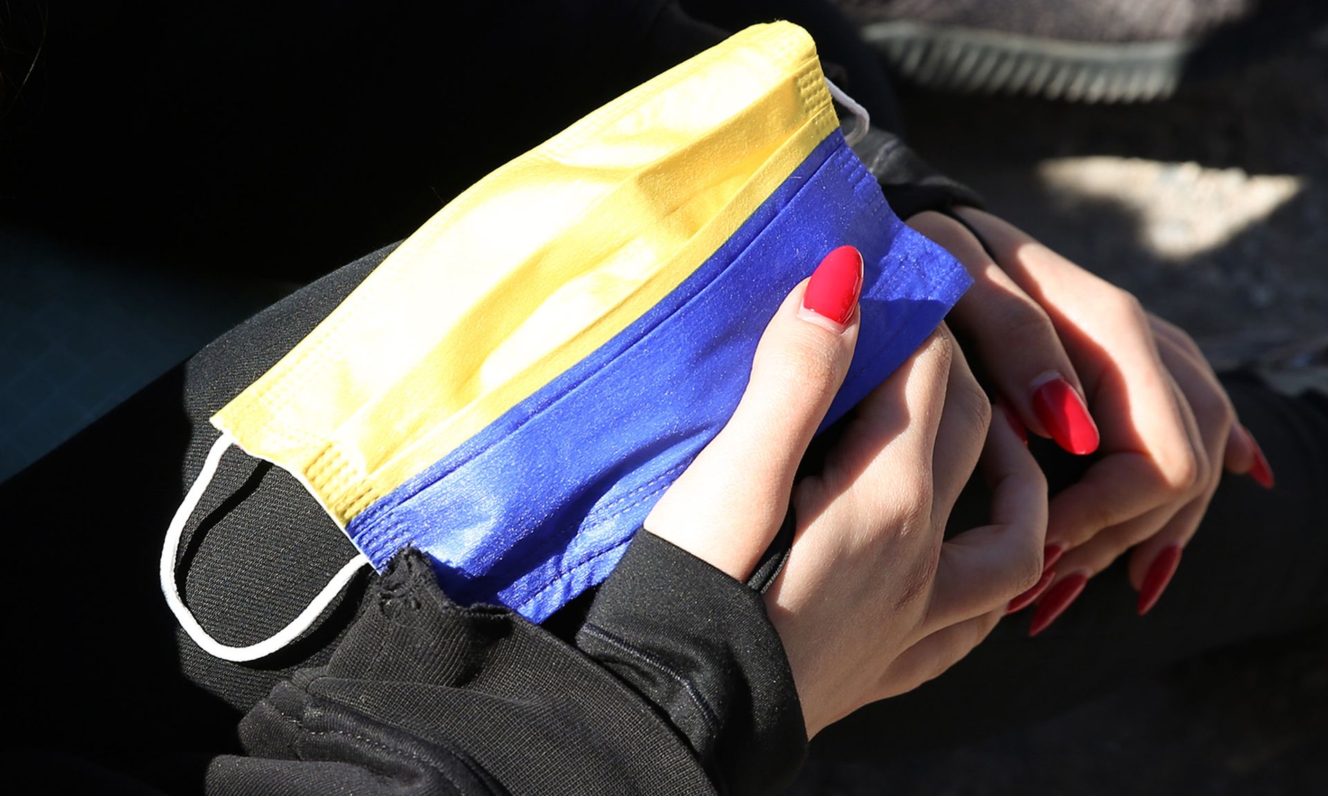 Russian activist Polina Oleinikova holds a face mask with the colors of the Ukraine flag as she participates in a hunger strike outside the Russian embassy on April 16, 2022, in Berlin. (Photo by Adam Berry/Getty Images)