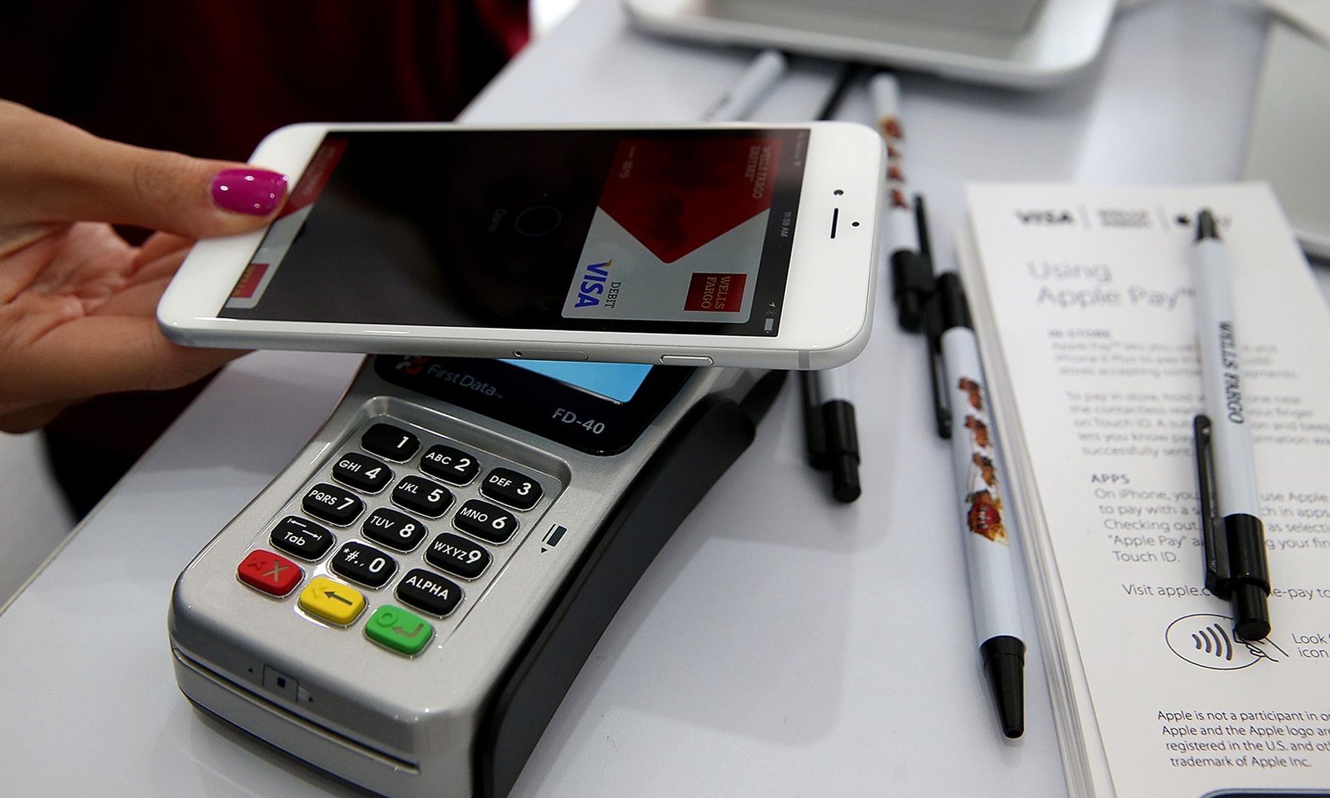 Criminals looking to cash in on customers moving to mobile and internet banking. Pictured: A worker demonstrates Apple Pay inside a mobile kiosk sponsored by Visa and Wells Fargo on Oct. 20, 2014, in San Francisco. (Photo by Justin Sullivan/Getty Images)