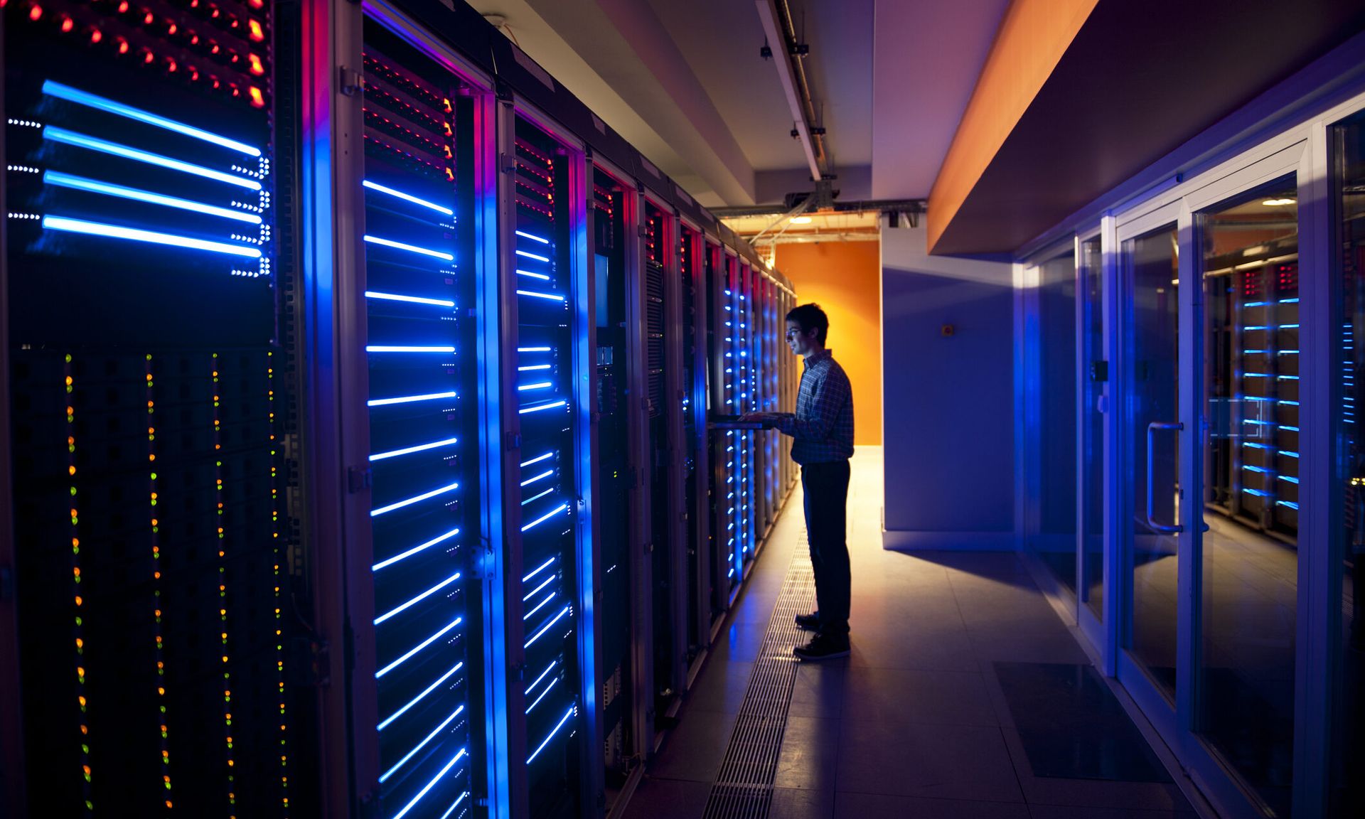 Technician configuring servers on racks.