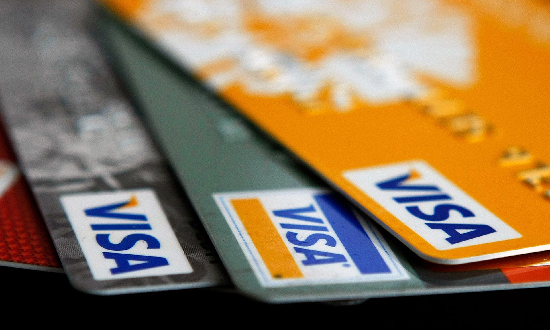 Visa credit cards are arranged on a desk.