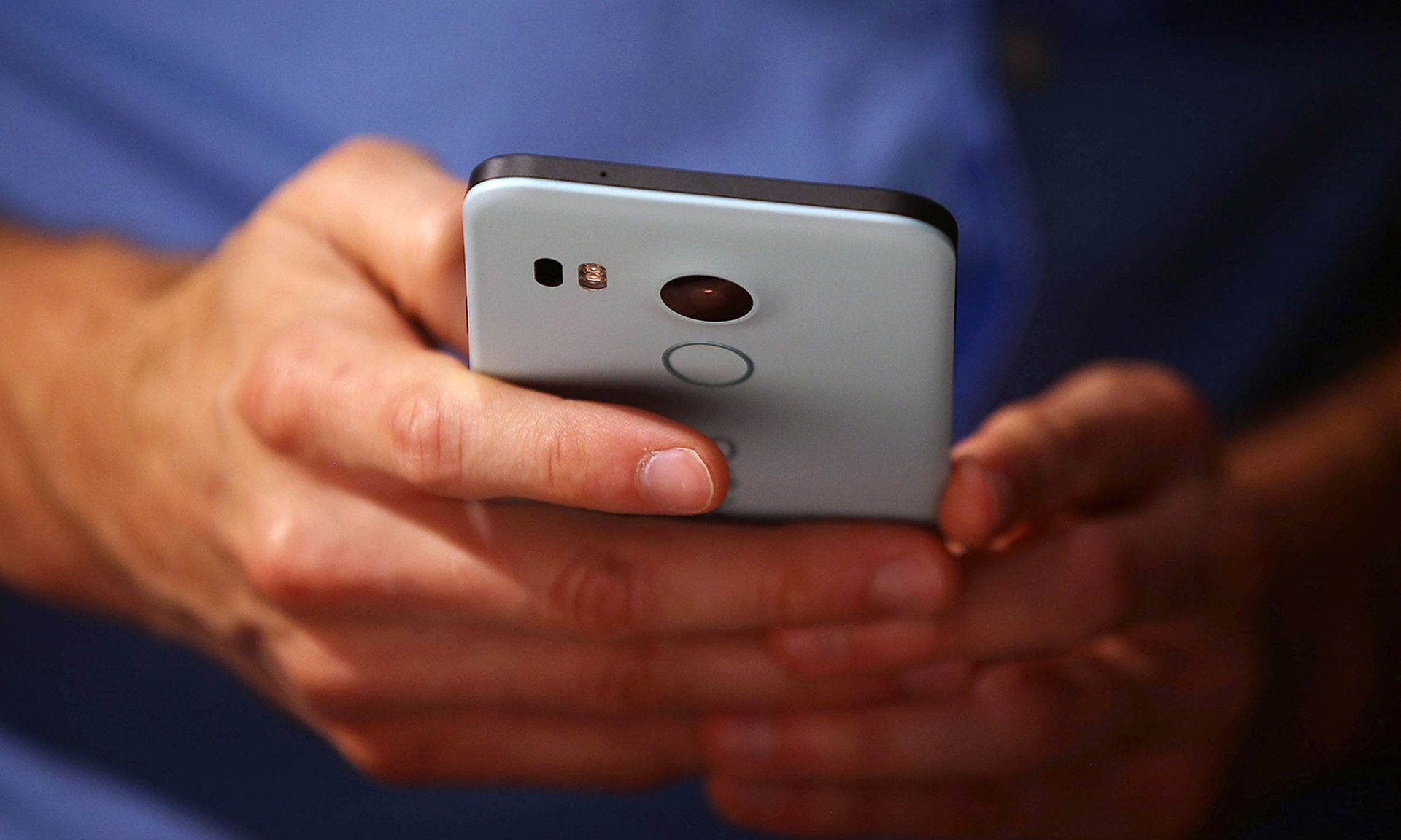An attendee inspects a Nexus 5X phone