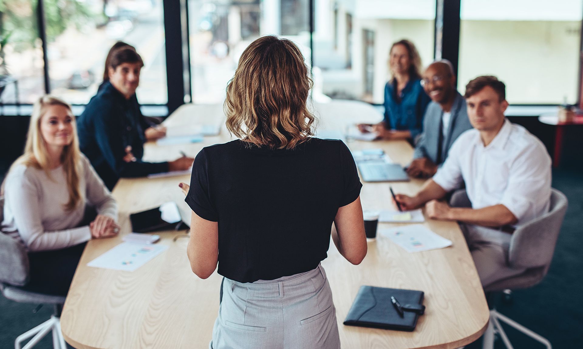 Female manager having a meeting with her team in office boardroom.