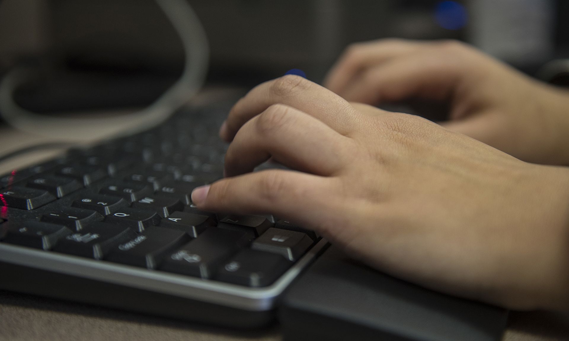 A customer service technician types on a computer.