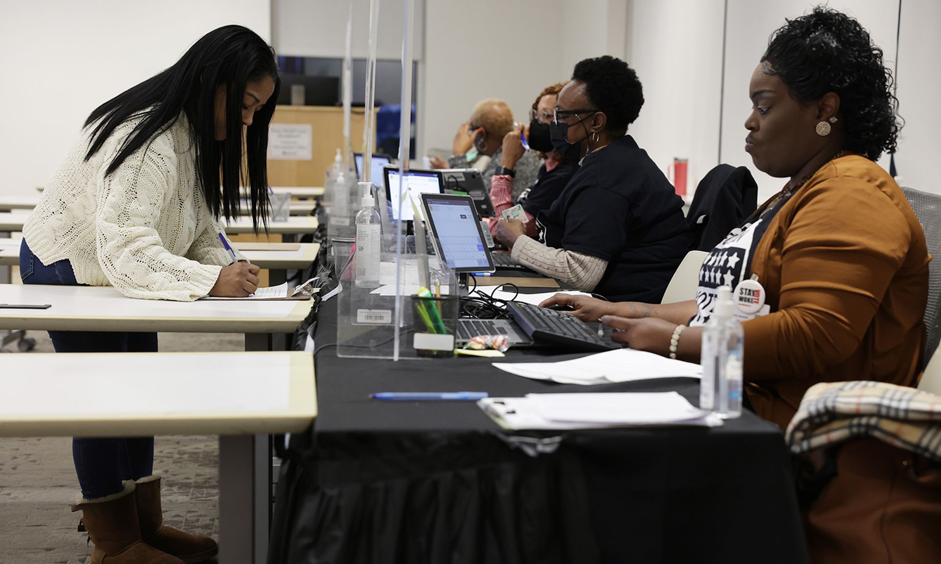 A resident fills out paperwork as she participates in early voting at a polling station