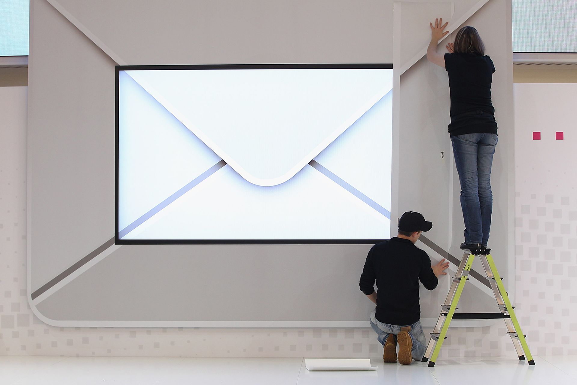 Workers prepare a presentation of advanced email at a technology trade fair.