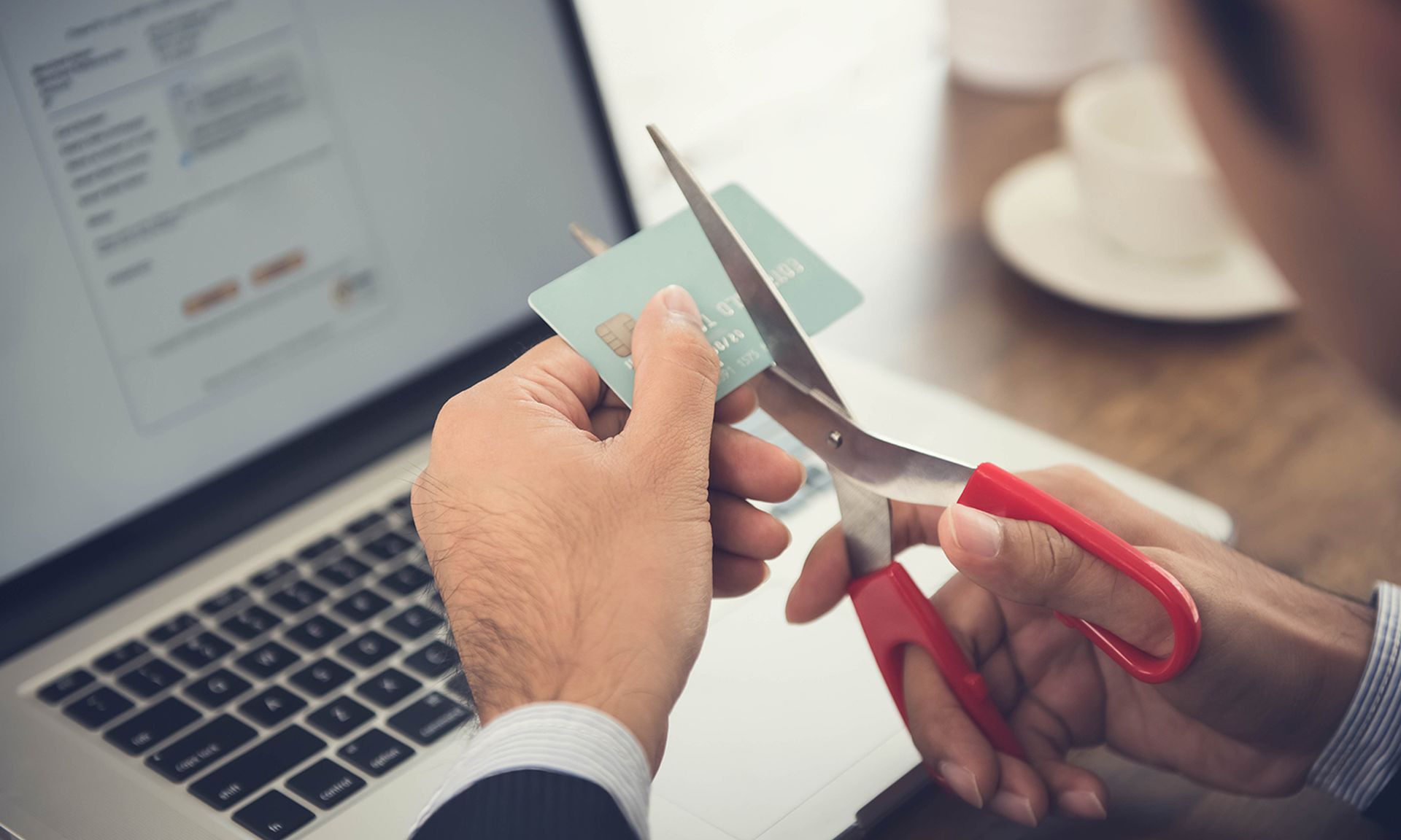 Businessman cutting a credit card that canceled by financial institute due to negligent usage.