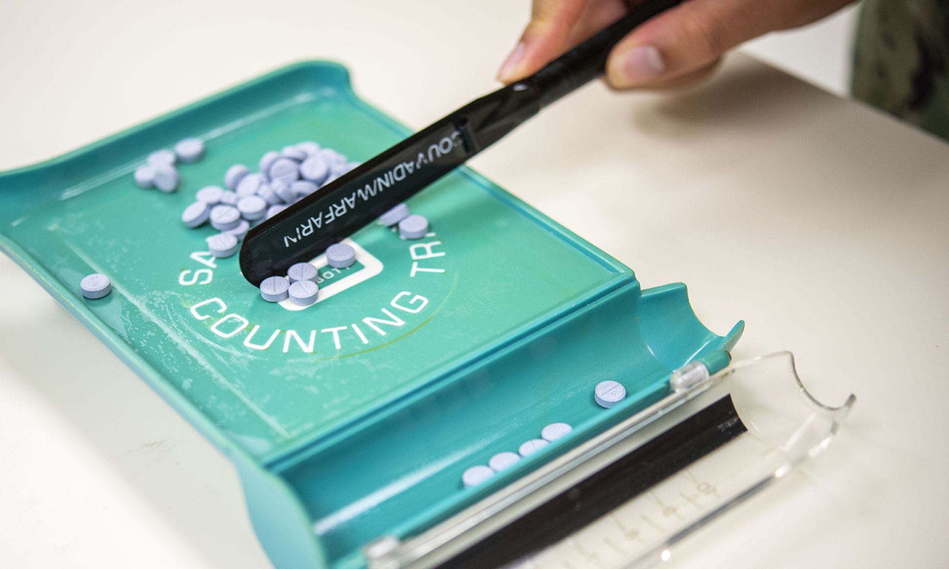 A pharmacist measures a prescription