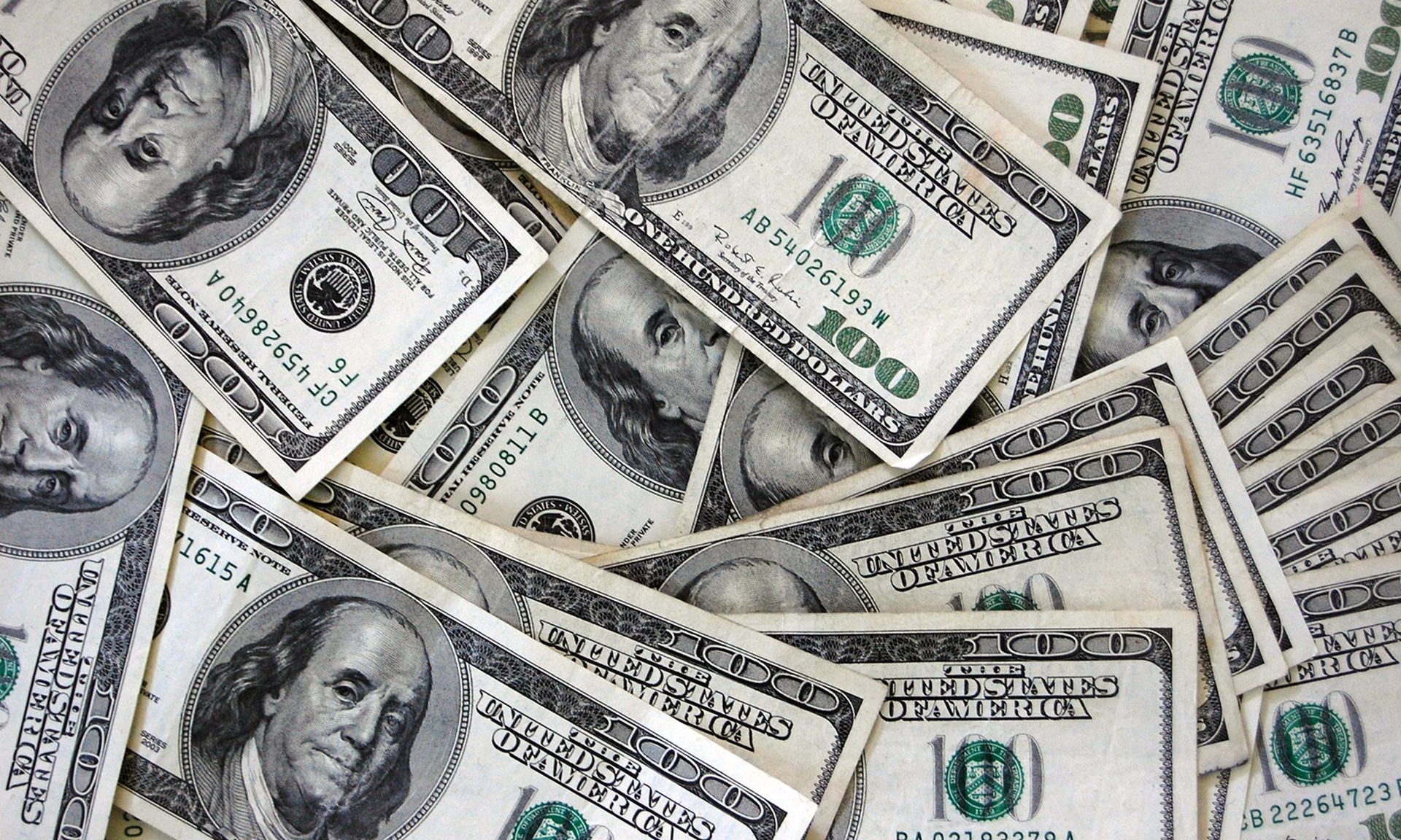 A scattering of $100 bills are seen