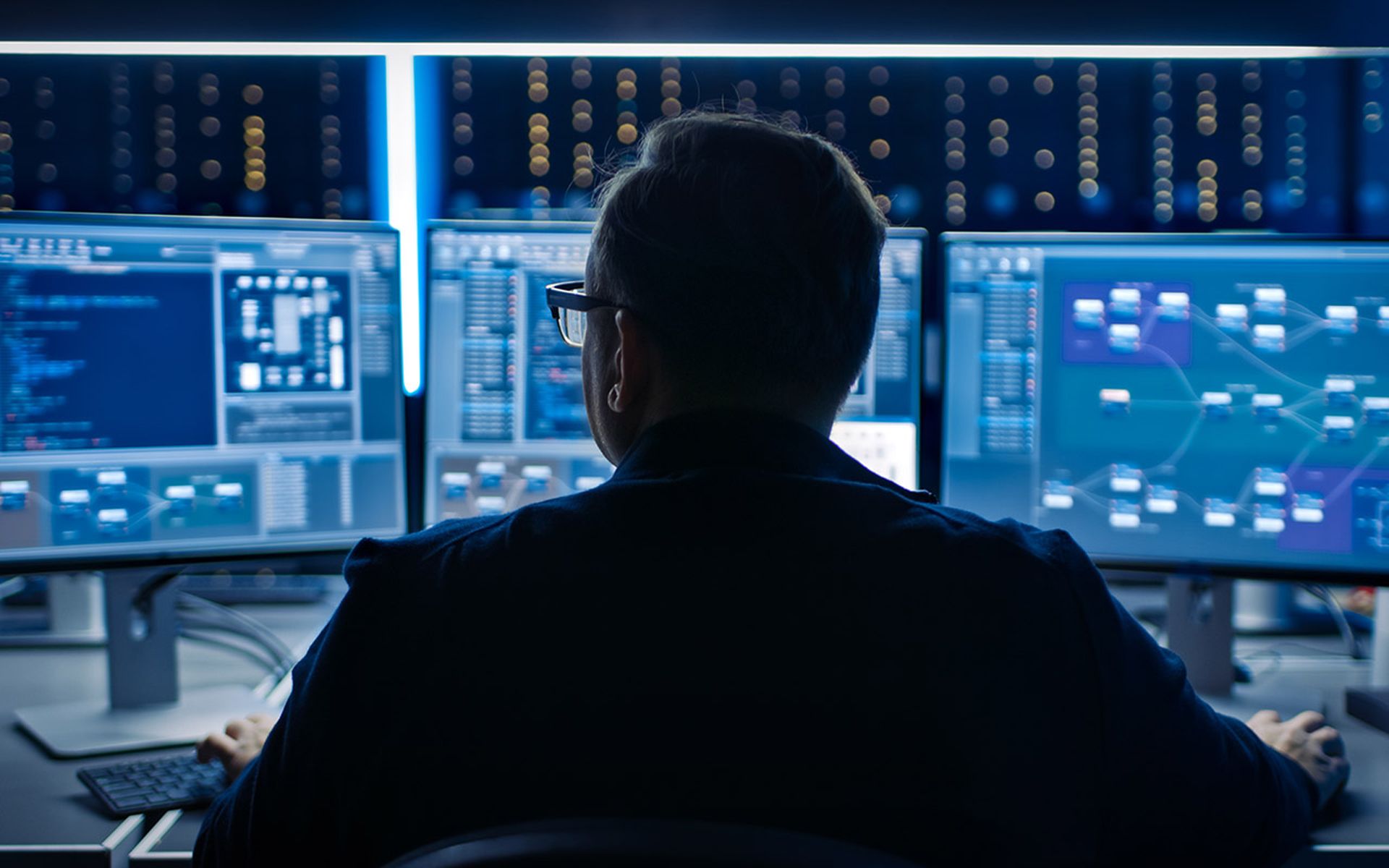 Professional IT Programer Working in Data Center on Desktop Computer with Three Displays