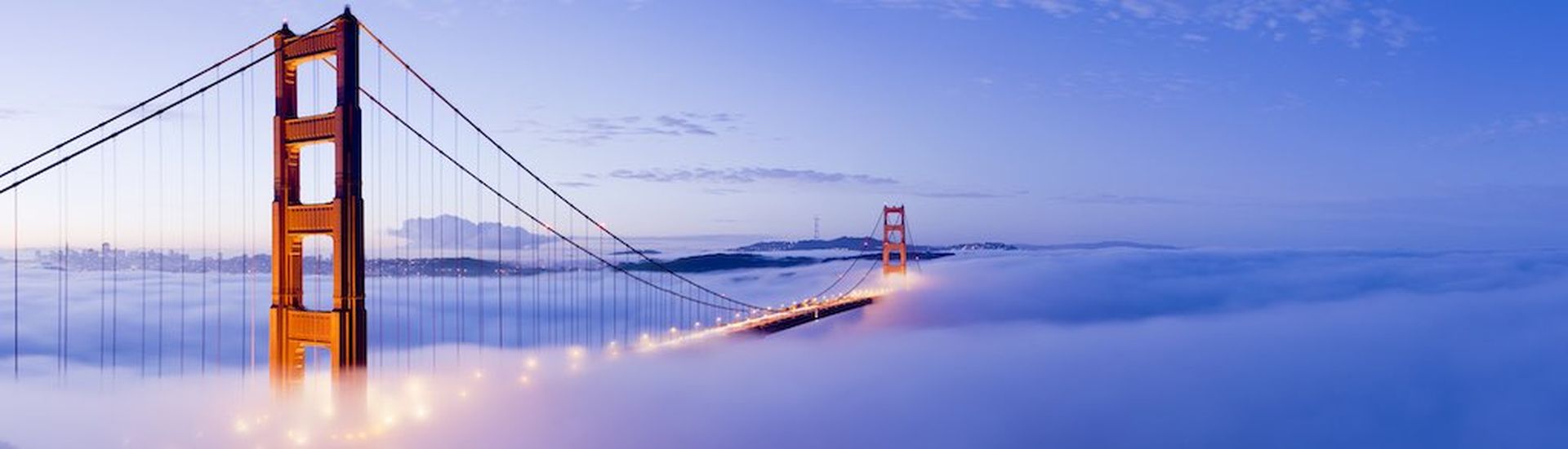 The Golden Gate bridge in San Francisco surrounded by fog at twilight, USA.