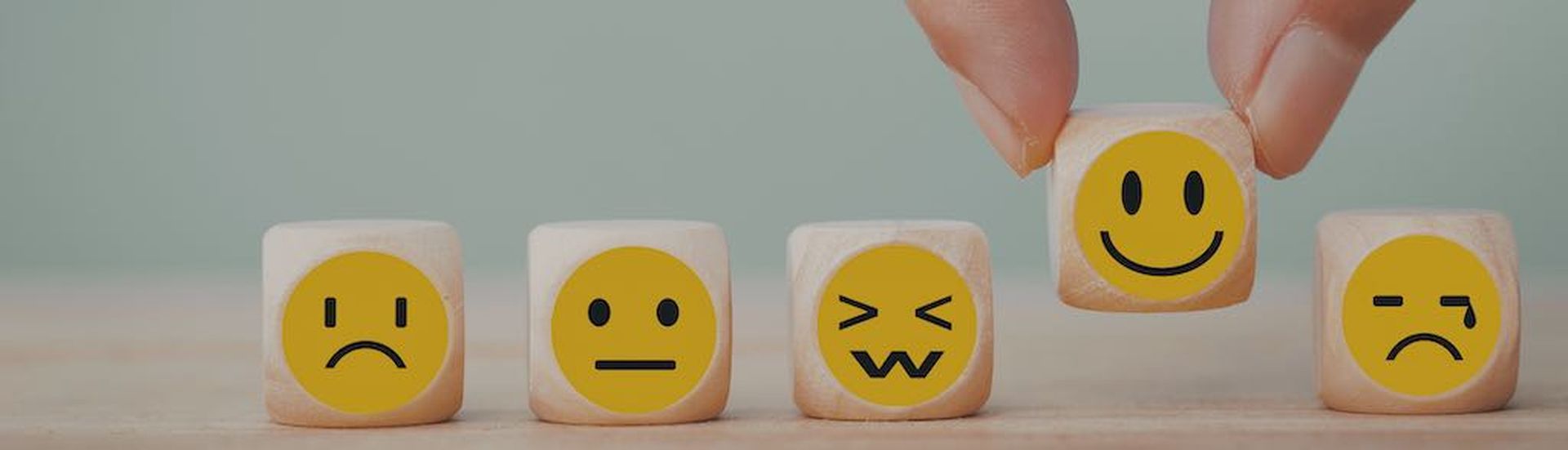 Hand chooses with happy smile face emoticon icons on Wooden Cube , good feedback rating for customer review survey