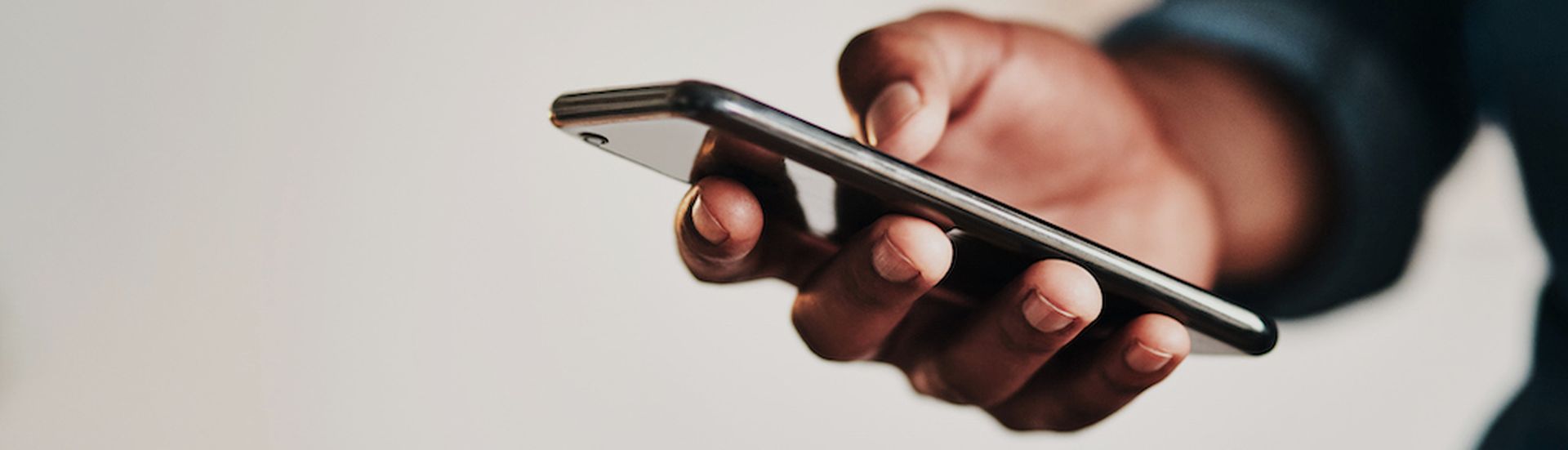 Cropped shot of an unrecognizable businessman standing alone in his home office and texting on his cellphone