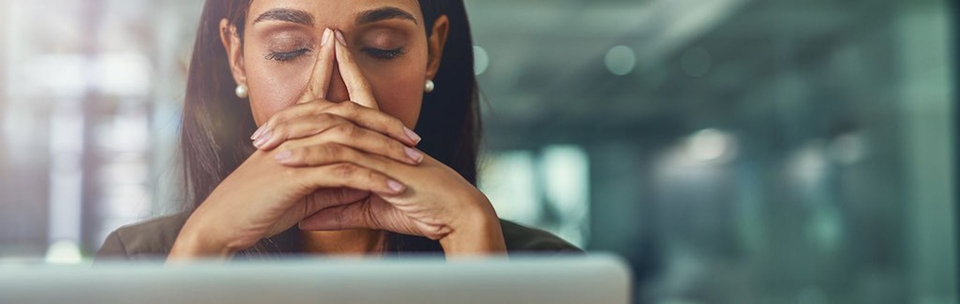 Shot of a young businesswoman looking stressed out while working in an office