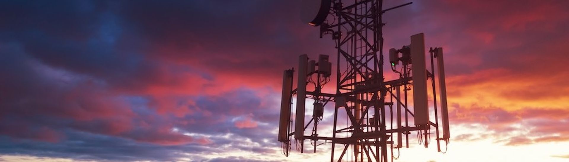 Aerial drone view of a cellular tower in evening light.