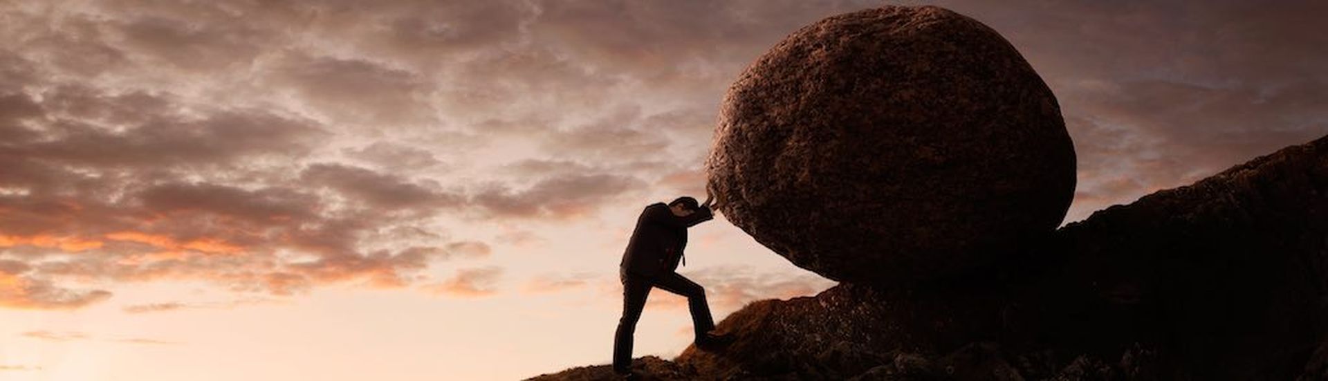 Business concept, Young businessman pushing large stone uphill with copy space