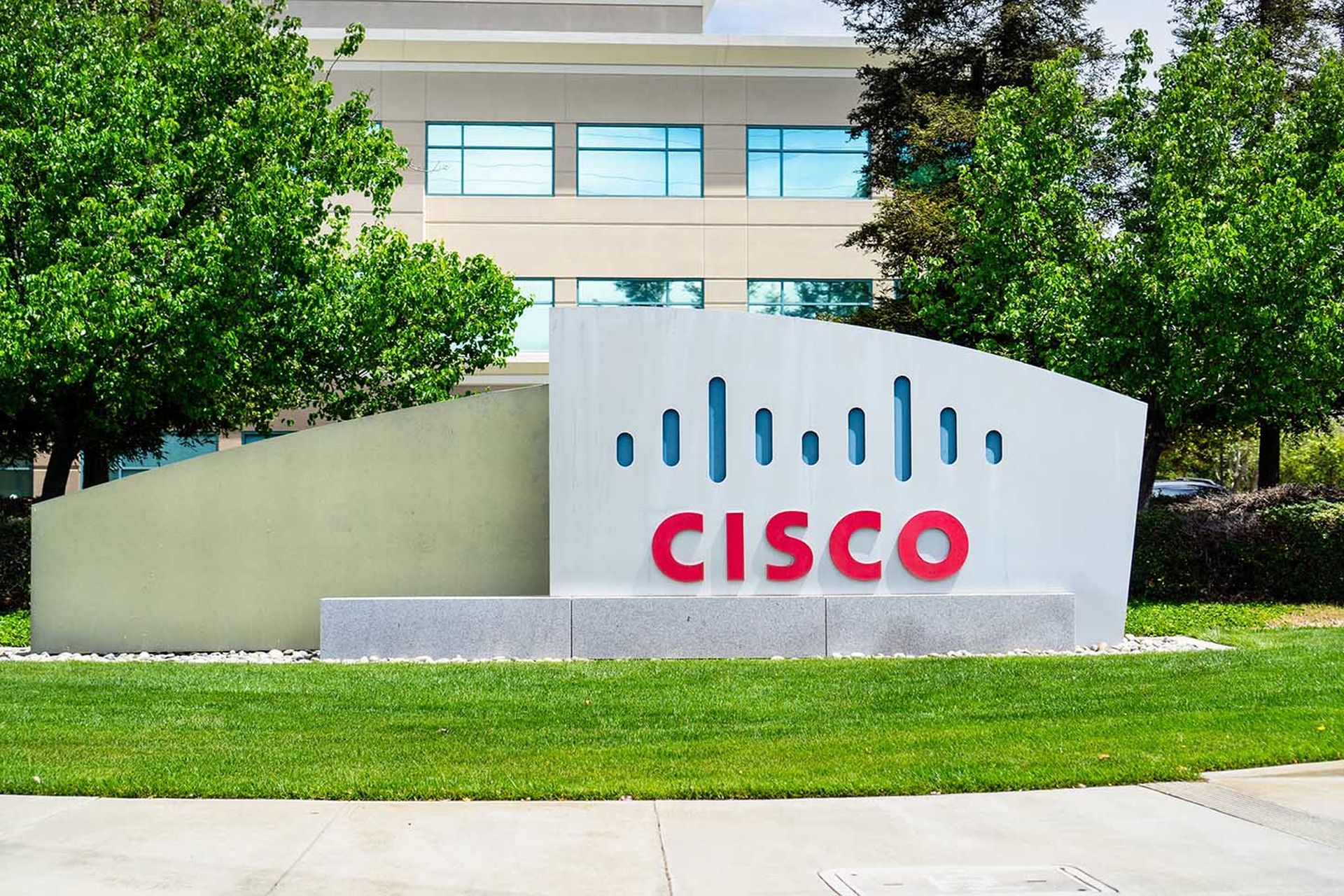 A sign with the Cisco logo is seen outside of a building