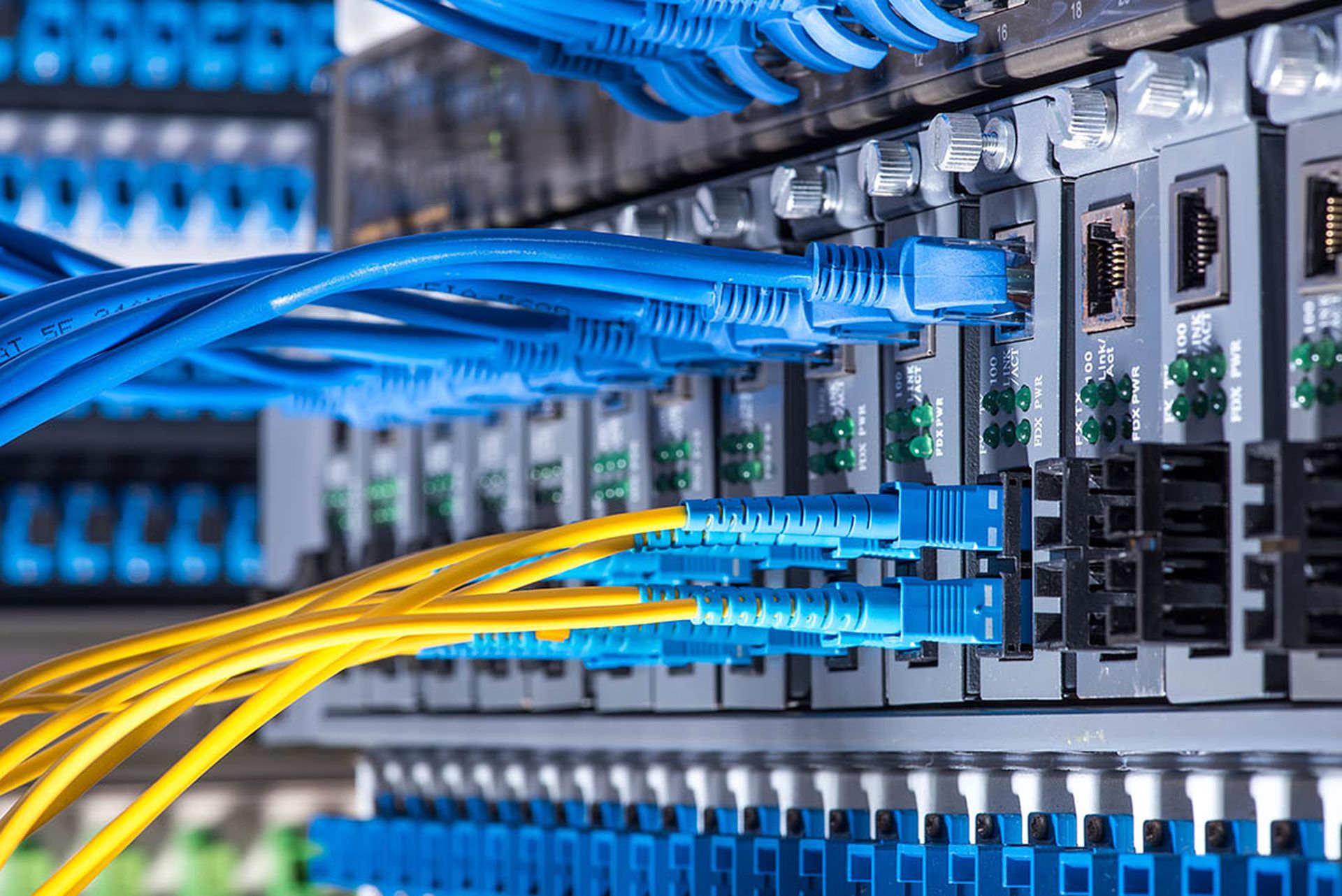 Fiber Optic cables connected to an optic ports and Network cables connected to ethernet ports