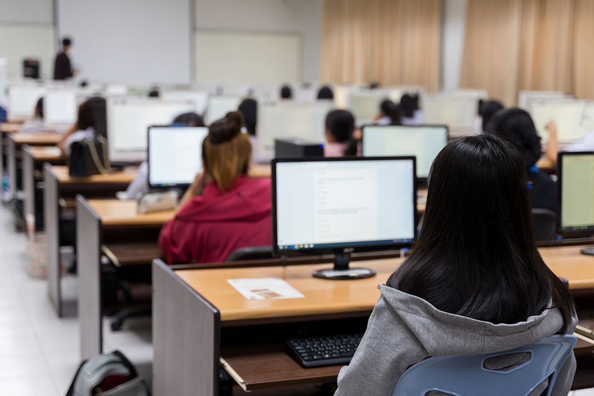 Blur and selective focus of the university student using computer studying in computer room. Group of students in study in computers room.