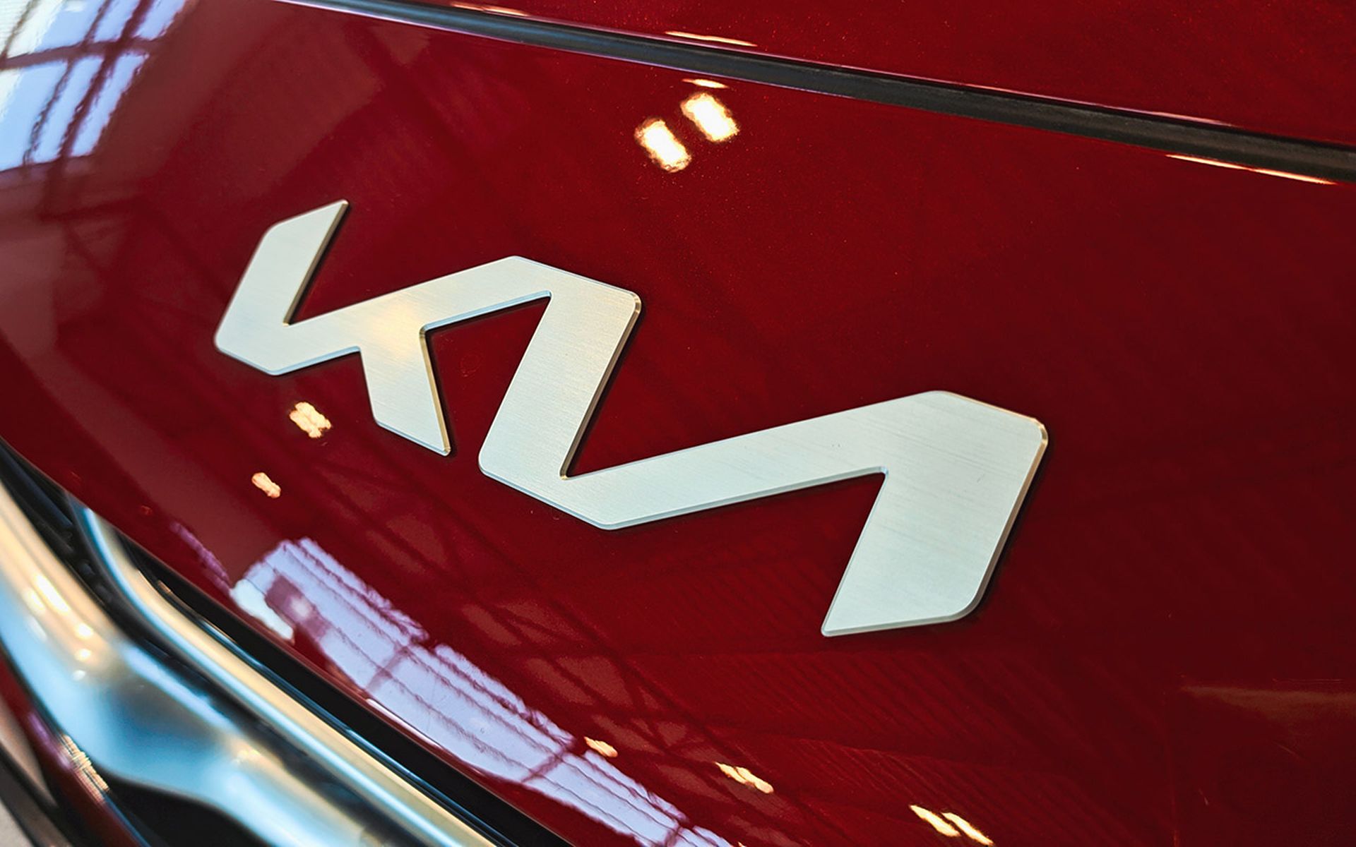 KIA Motors logo sign on car of red color