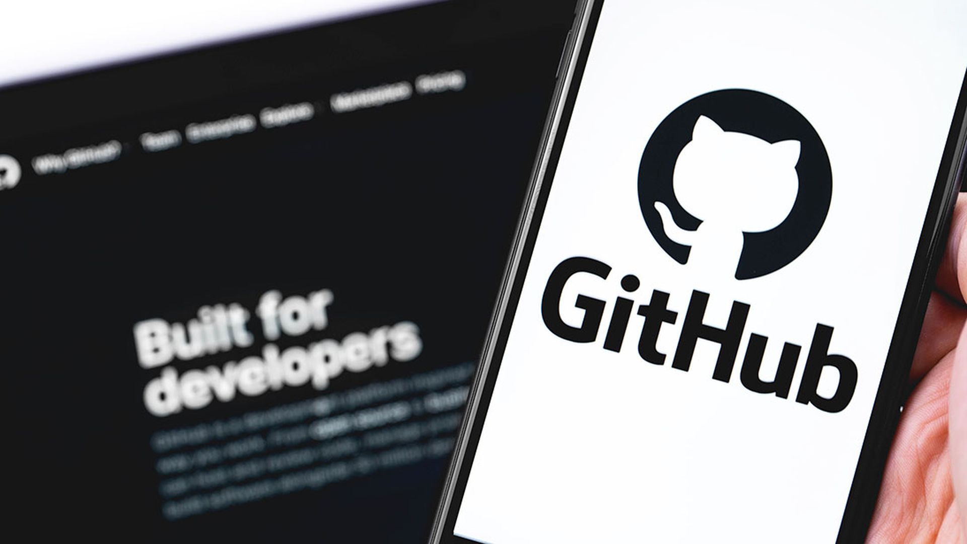 GitHub logo on the screen smartphone and notebook closeup. GitHub is the largest web service for hosting and developing IT projects.