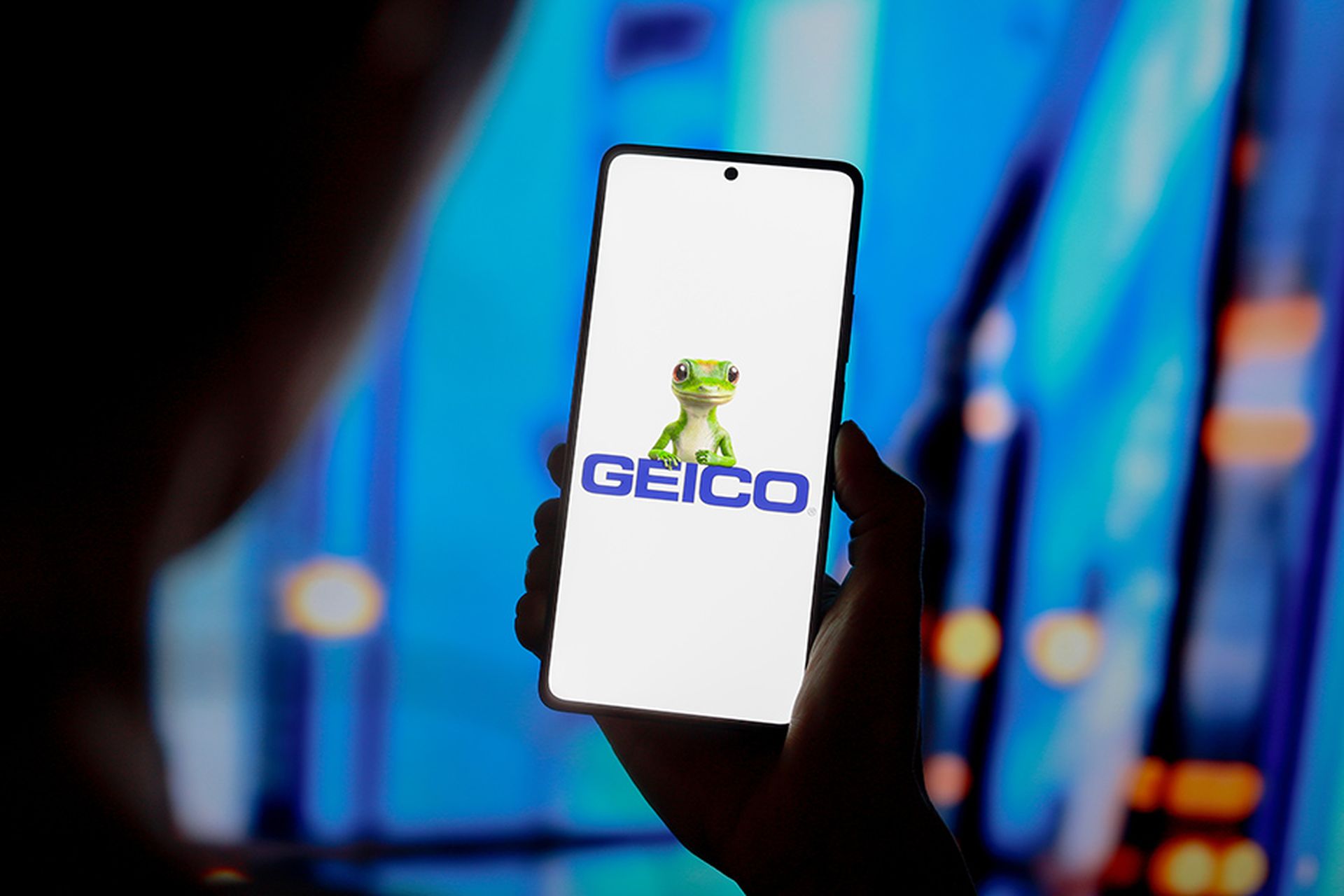 the Government Employees Insurance Company (Geico) logo is displayed on a smartphone screen.