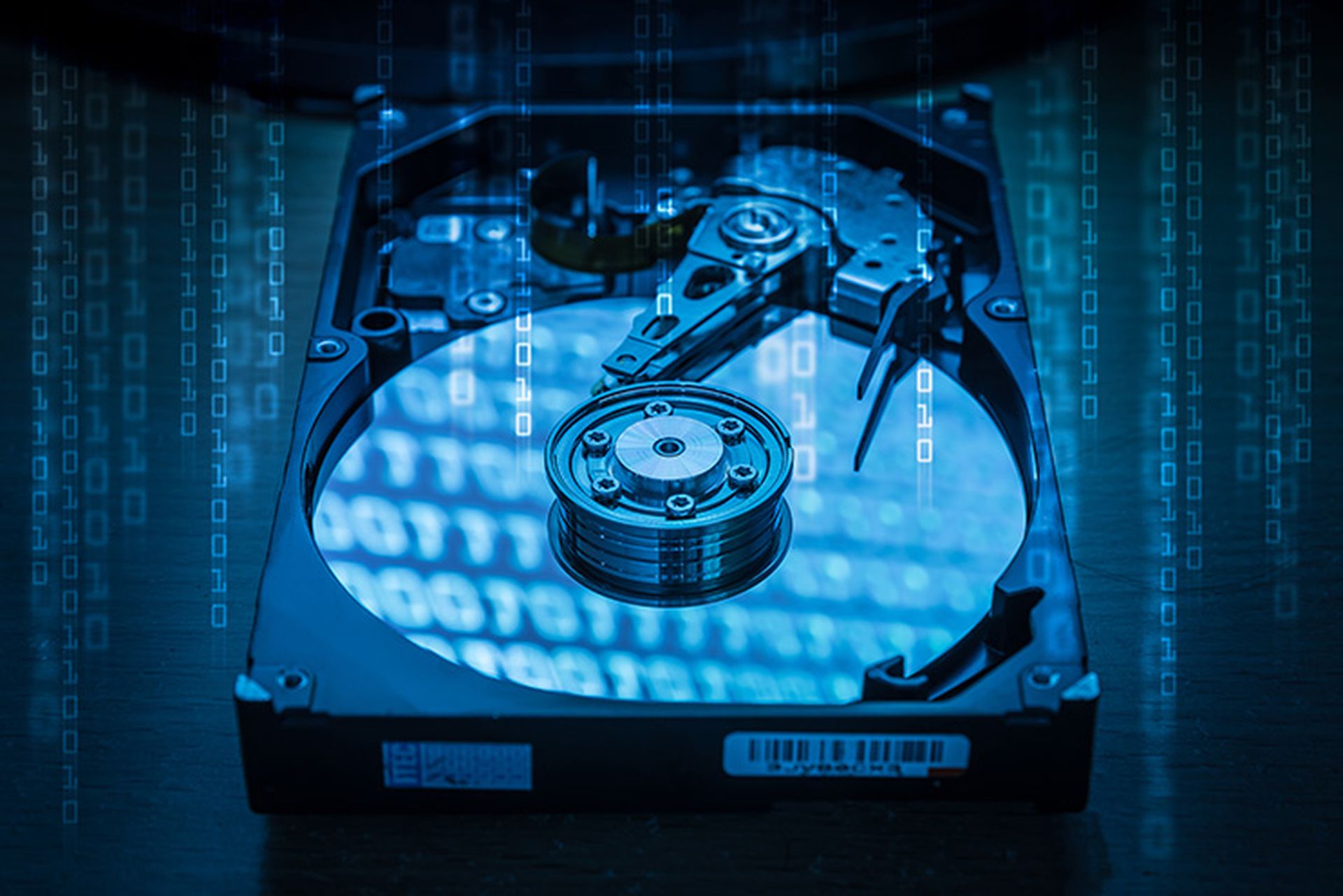 The abstract image of inside of hard disk drive and binary code hologram on top. the concept of data, hardware, and information technology.