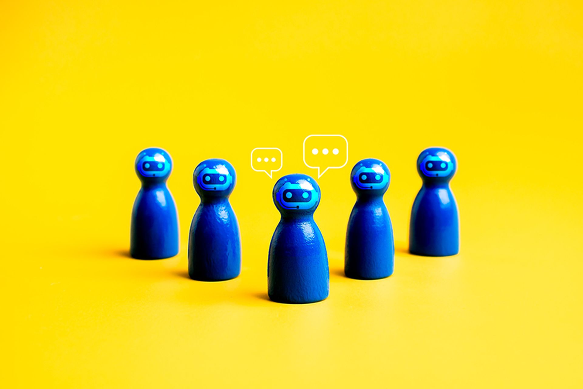 AI assistant, business and technology, chatbot team support service concept. Group of blue peg dolls with chat robot face icon, standing together with conversation on yellow background, minimalist.