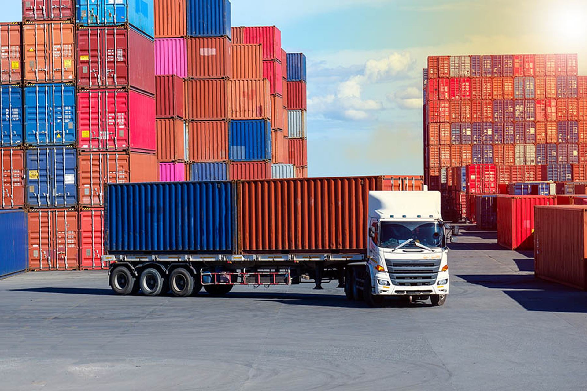 Container truck in cargo yard against blue sky transport background
