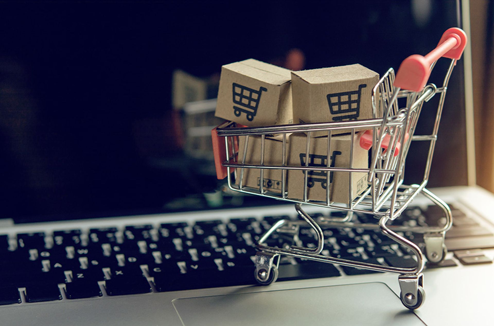 Shopping online. cardboard box with a shopping cart logo in a trolley on a laptop keyboard. Shopping service on The online web.