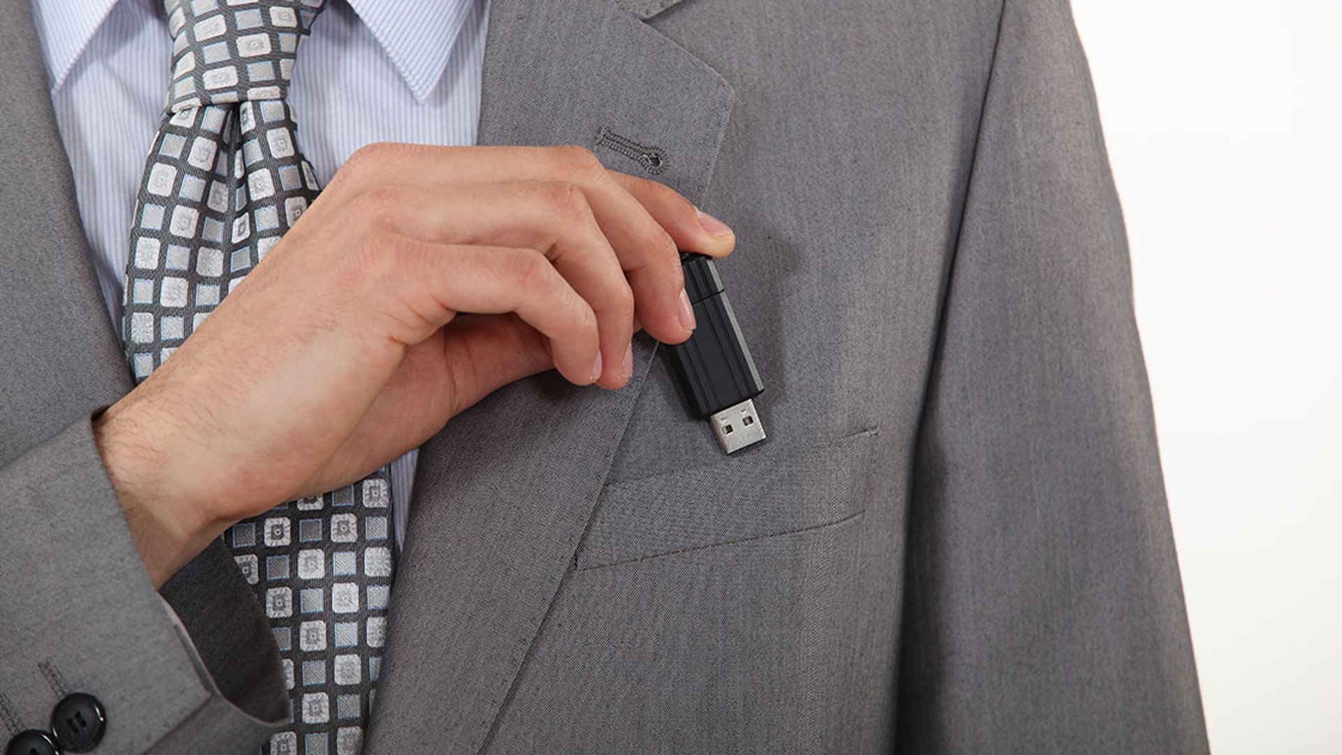 businessman putting a flash drive in his pocket