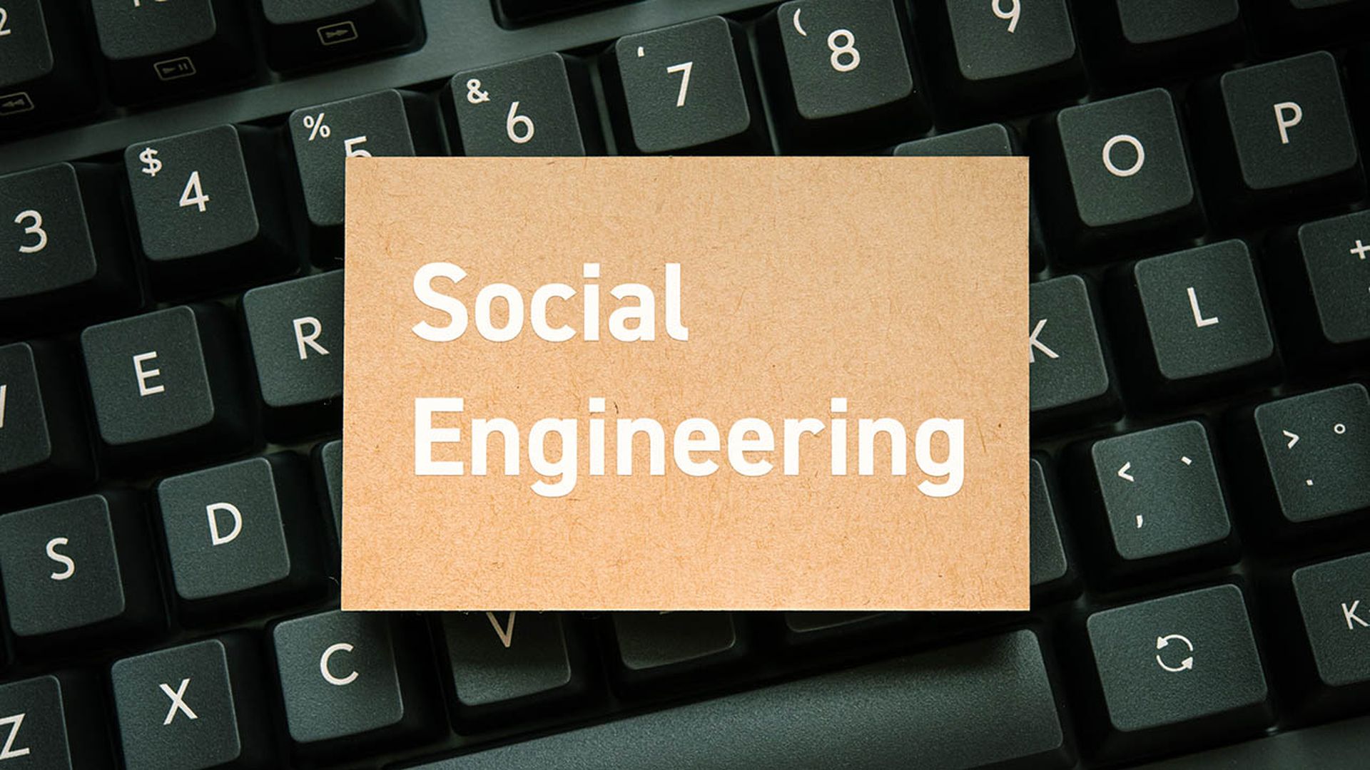 Social engineering cyber threat — growing human hacking attack concept for security awareness article, card on black keyboard