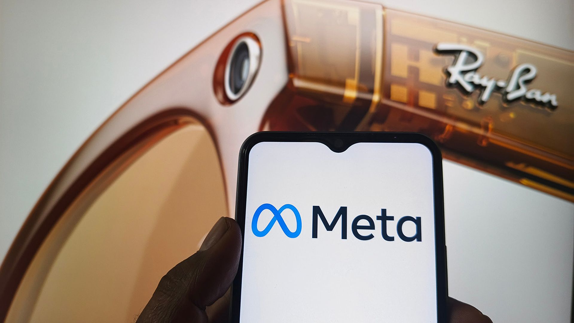 Meta logo on smartphone screen with Ray-Ban smart glasses