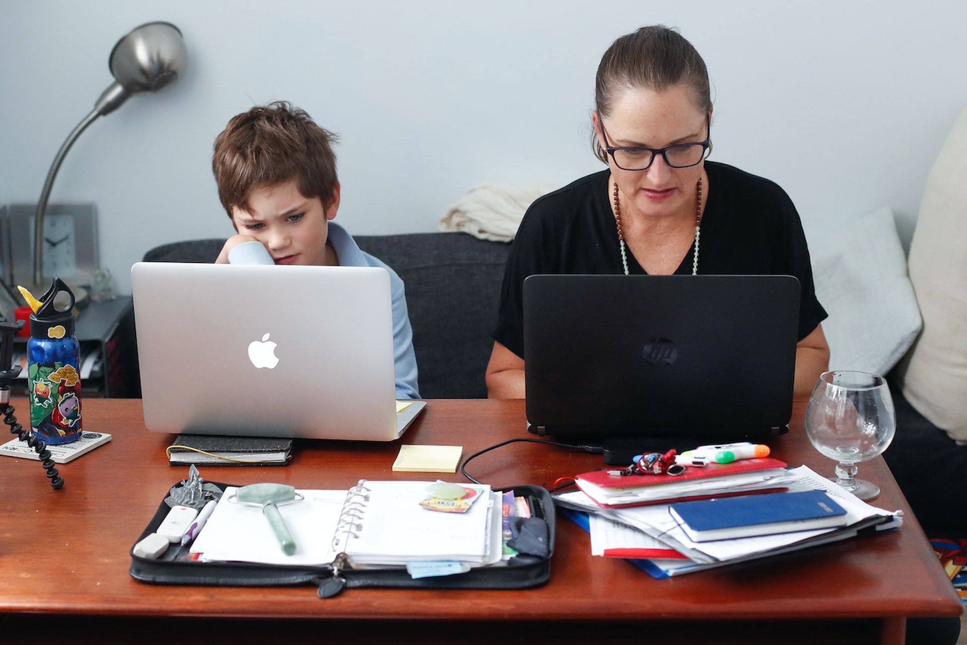 A mother and son work on their laptops in Sydney, Australia. Columnist Steve Banda of Lookout explains why the pandemic has made it more necessary than ever for companies to have a mobile security strategy. (Photo by Brendon Thorne/Getty Images)