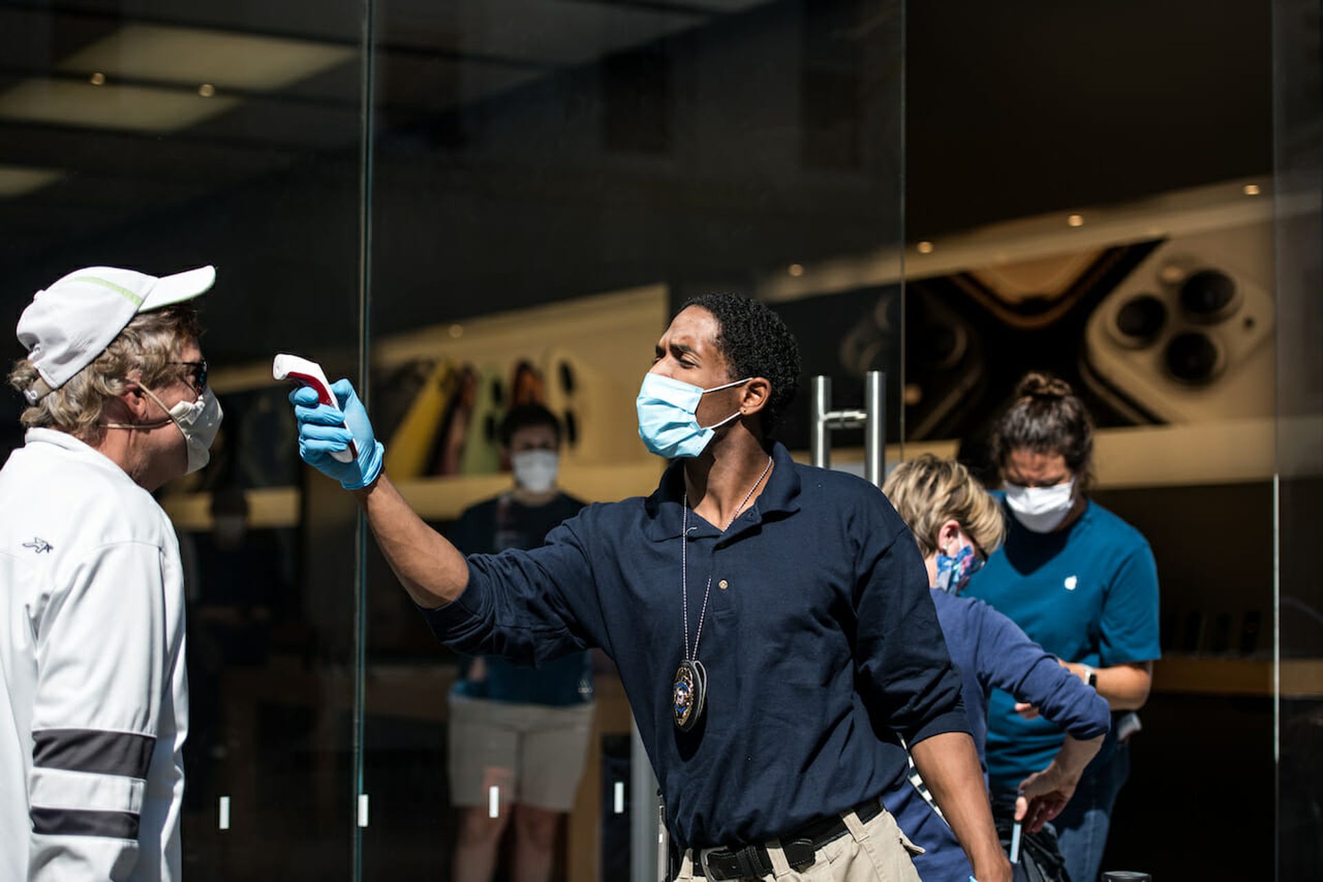 A security guard checks a customer’s temperature outside the Apple Store last May in Charleston, S.C. Today’s columnist, Kurtis Minder of GroupSense, says collecting health care data without sustaining a breach will be one of the many challenges ahead for security teams. (Photo by Sean Rayford/Getty Images)