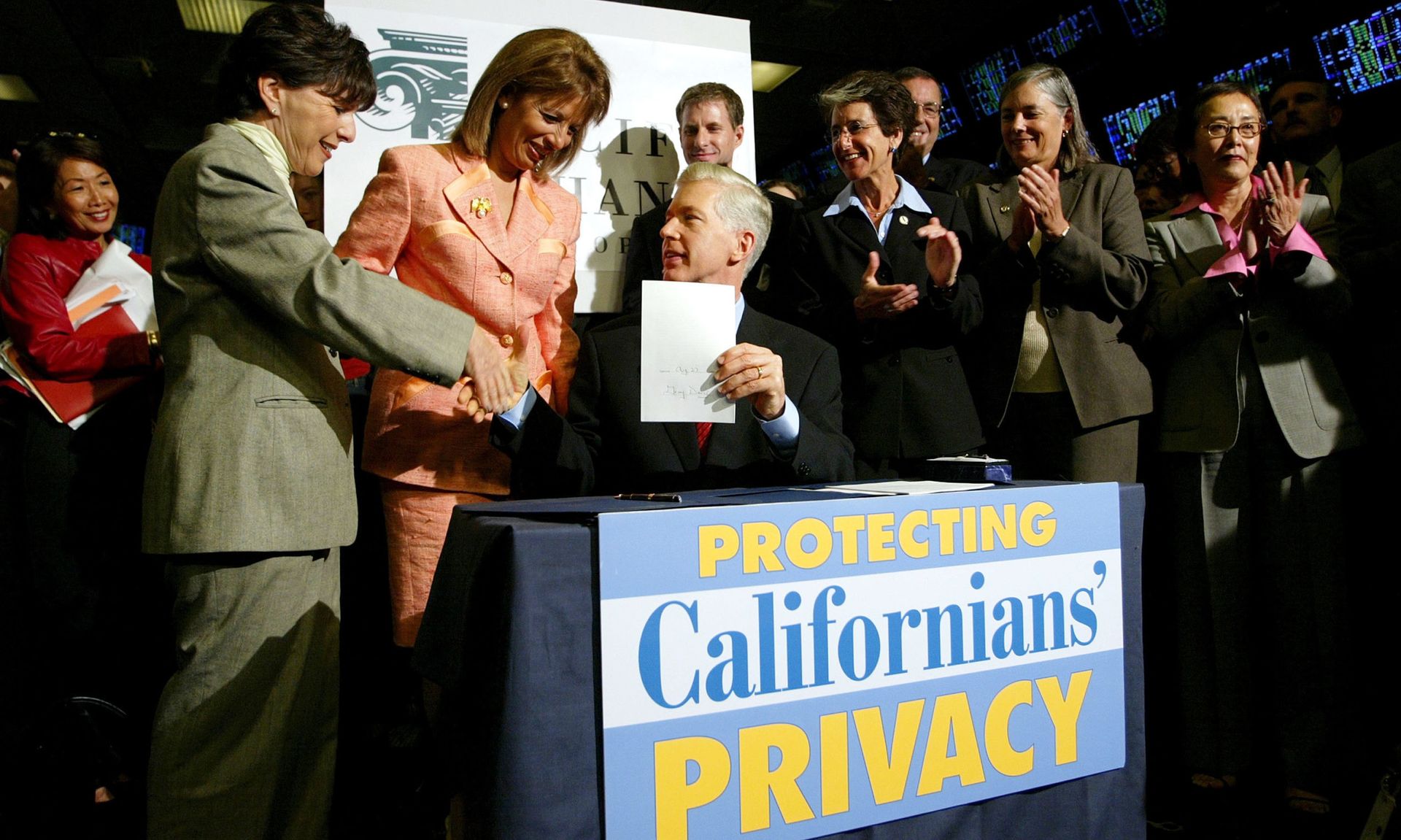 Former California Gov. Gray Davis signs a financial privacy bill at the Pacific Stock Exchange in 2003 in San Francisco, California. Davis signed the California Information Privacy Act, which would prohibit financial institutions from sharing or selling identifiable non-public information without obtaining a consumer&#8217;s consent.  (Justin Sulli...