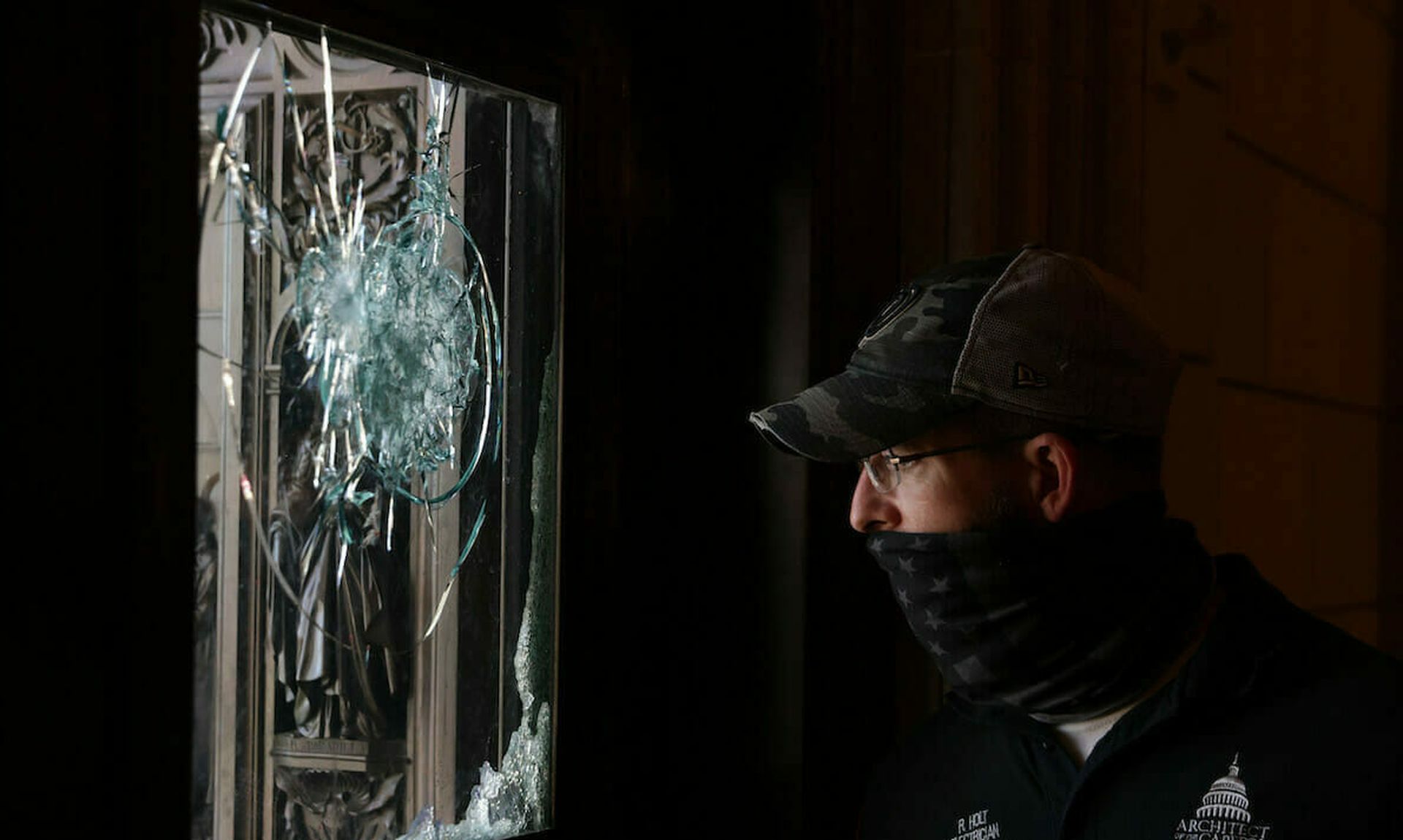 A member of the Architect of the Capitol inspects a damaged entrance of the U.S. Capitol January 7, 2021 in Washington, DC., after pro-Trump mobs stormed the building. (Photo by Alex Wong/Getty Images)
