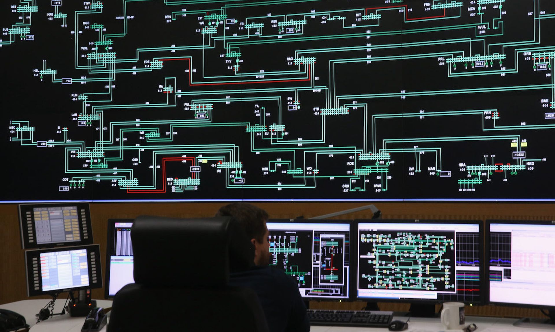 A technician monitors electricity levels in front of a giant screen showing the electricity transmission grid in a control center in Berlin, Germany.  (Photo by Sean Gallup/Getty Images)