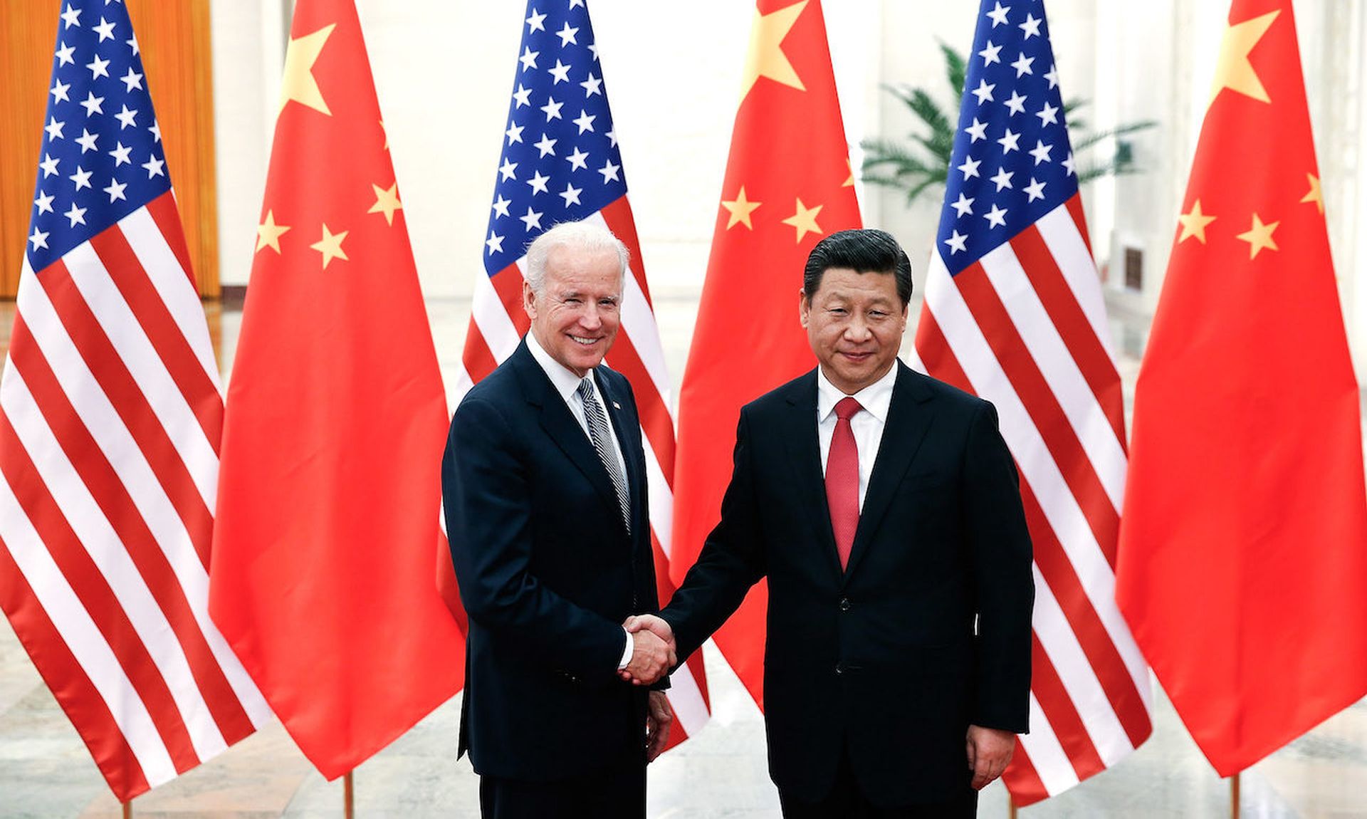 Chinese President Xi Jinping (R) shake hands with then U.S Vice President Joe Biden (L) inside the Great Hall of the People on December 4, 2013 in Beijing, China. Some question why the U.S. policies in response to cyberattacks out of China differ from those in response to Russia. (Photo by Lintao Zhang/Getty Images)