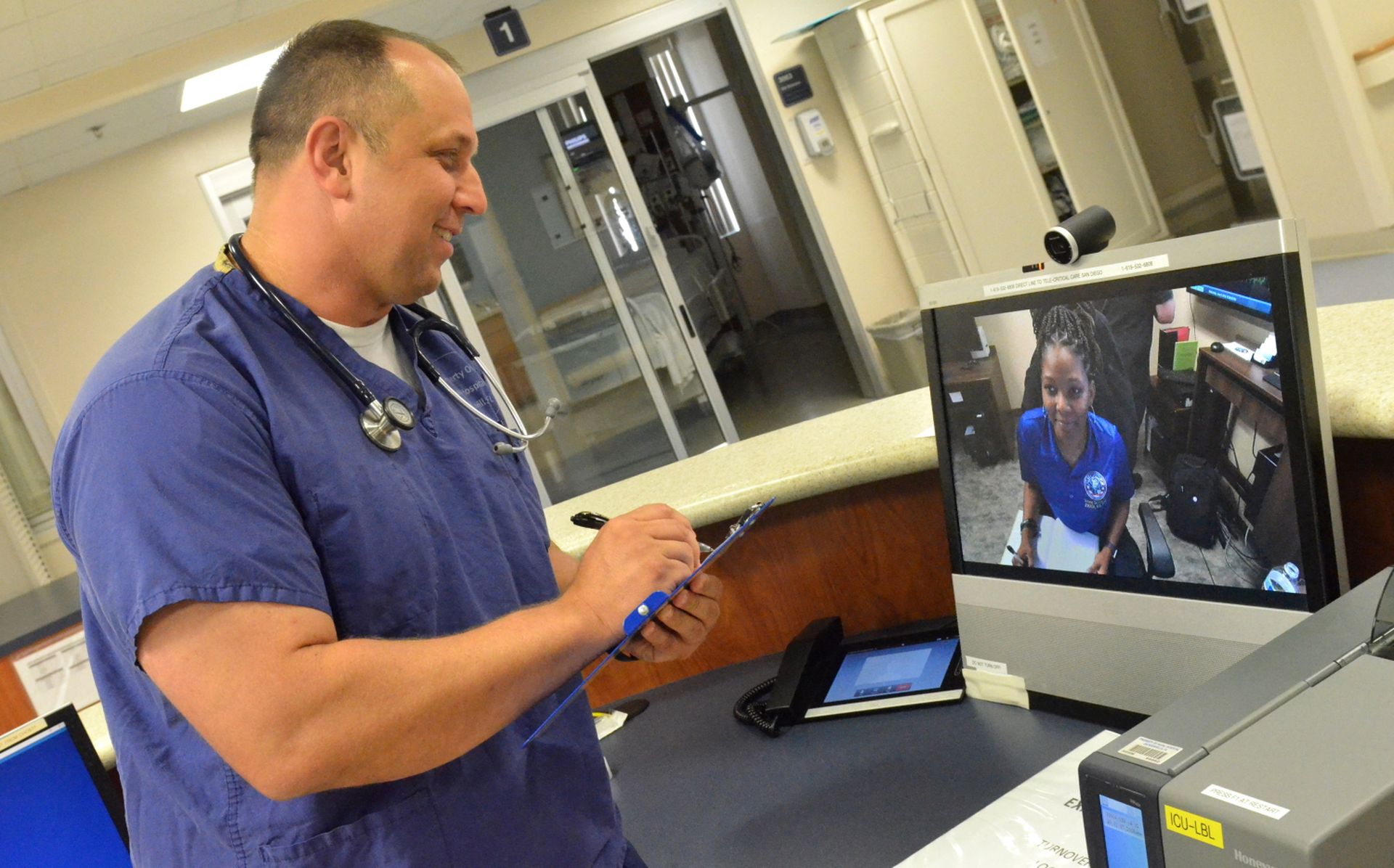 Lt. Michael White, a nurse at Naval Hospital Jacksonville’s intensive care unit, uses telehealth to discuss patient statuses and recommendations with Tiffany Ingram, a nurse at Naval Medical Center San Diego, on June 5, 2019. (Jacob Sippel/Navy)