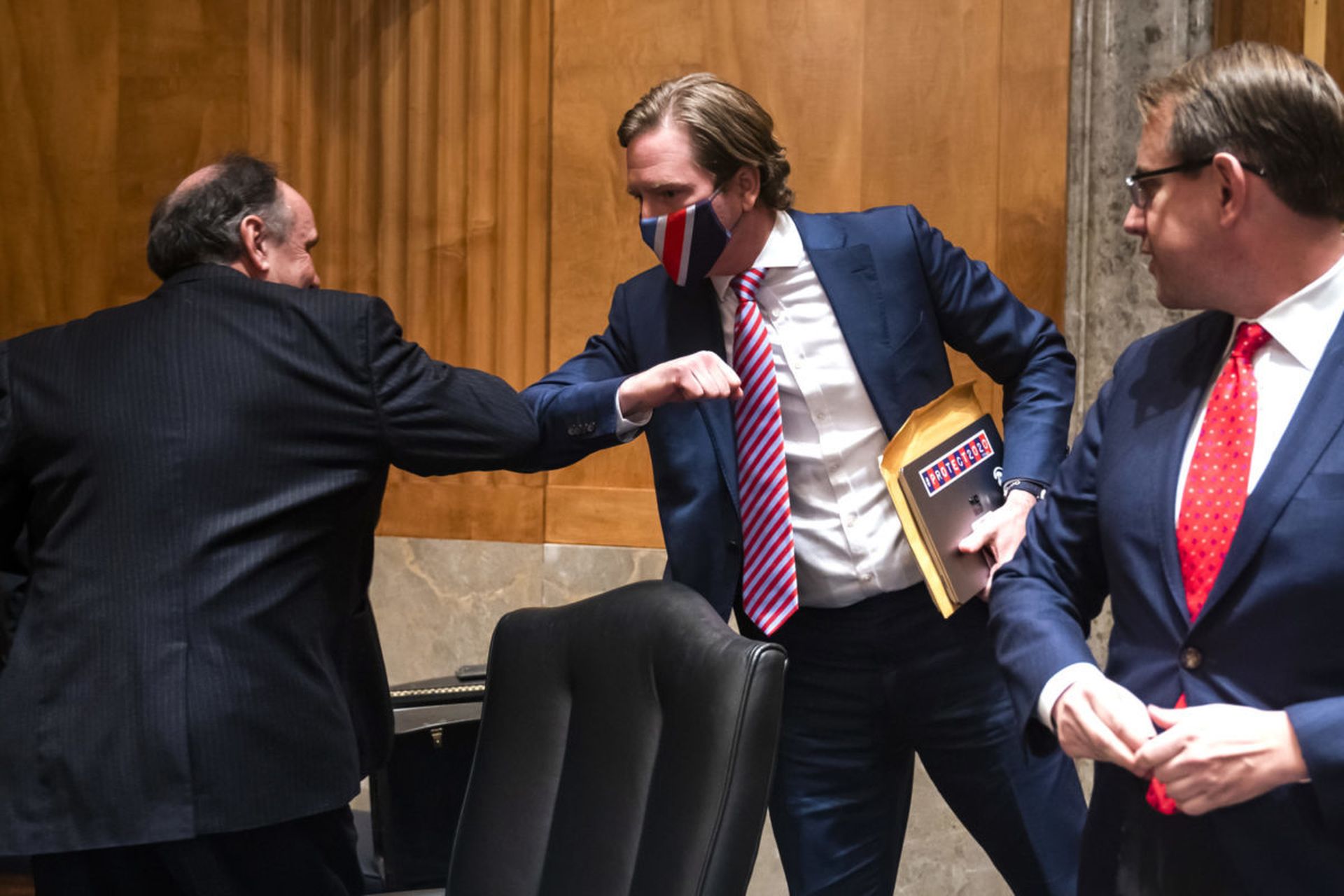 Former Cybersecurity and Infrastructure Security Agency Director Chris Krebs elbow bumps Trump campaign attorney James Troupis (L), while Trump campaign attorney Jesse Binnall (R) looks on following a Senate Homeland Security and Governmental Affairs hearing. Krebs said he supports Congress passing enhanced insider threat program requirements on f...