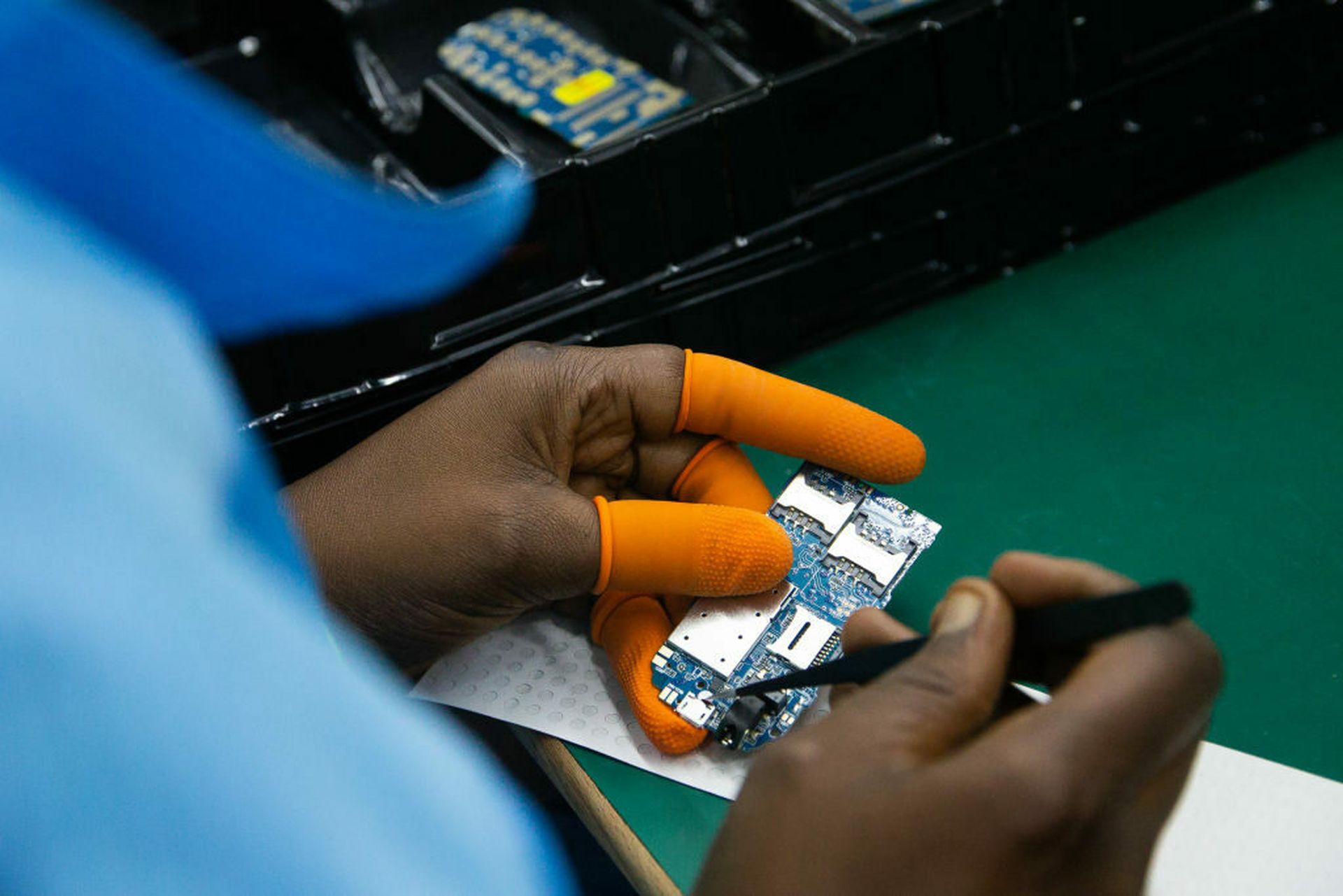 A Ugandan factory worker assembles a mobile phone mother board on December 02, 2019 in Namanve, Uganda. Mapping out weaknesses and interdependencies in the Information Communications Technology supply chain will be among several new projects that CISA will put out to bid early next year. (Photo by Luke Dray/Getty Images)
